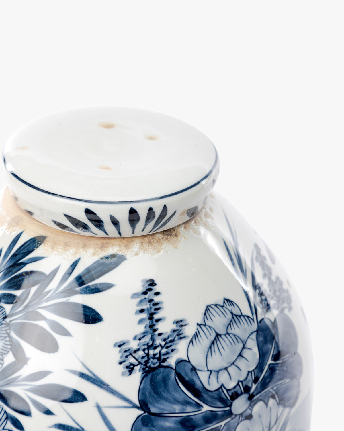 A close-up of the Chinoiserie Ginger Jar, featuring hand-painted blue and white floral patterns and a perforated white lid, set against a plain white background, by Vendixs