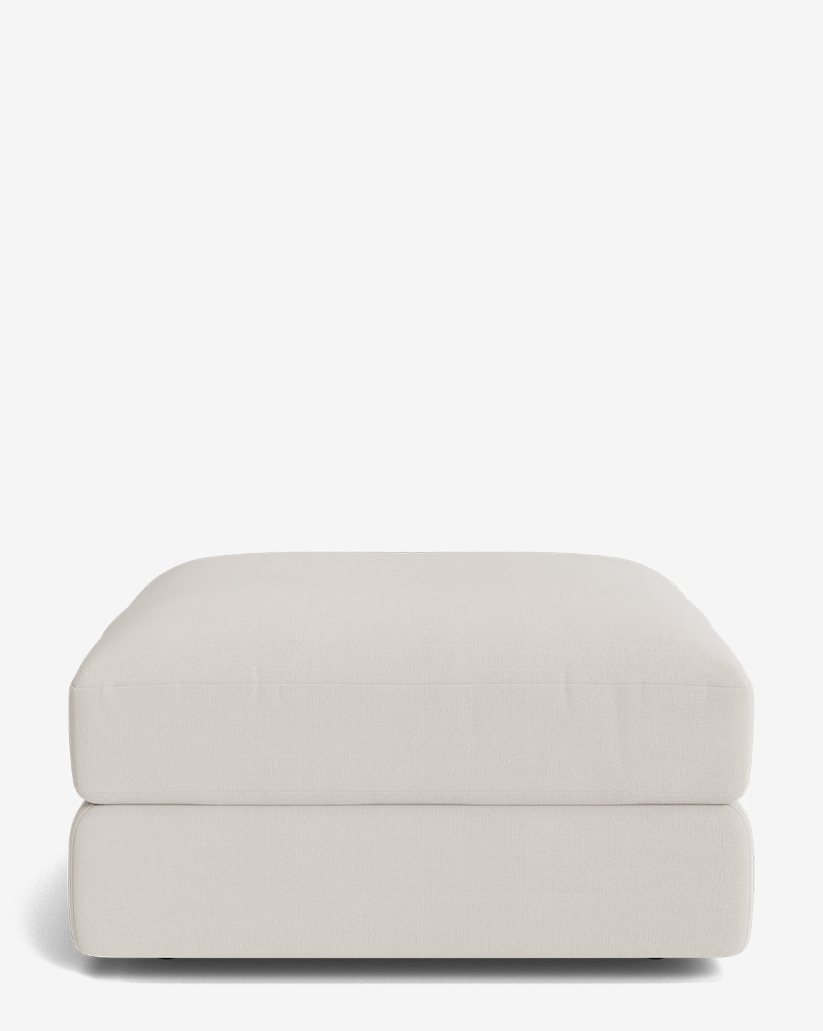 The Claremont Modular Ottoman by Makerspalm features a modern rectangular design, soft light beige fabric, clean lines, and a thick cushioned top. Part of the Claremont modular collection, it sits directly on the floor with no visible legs. Vendixs