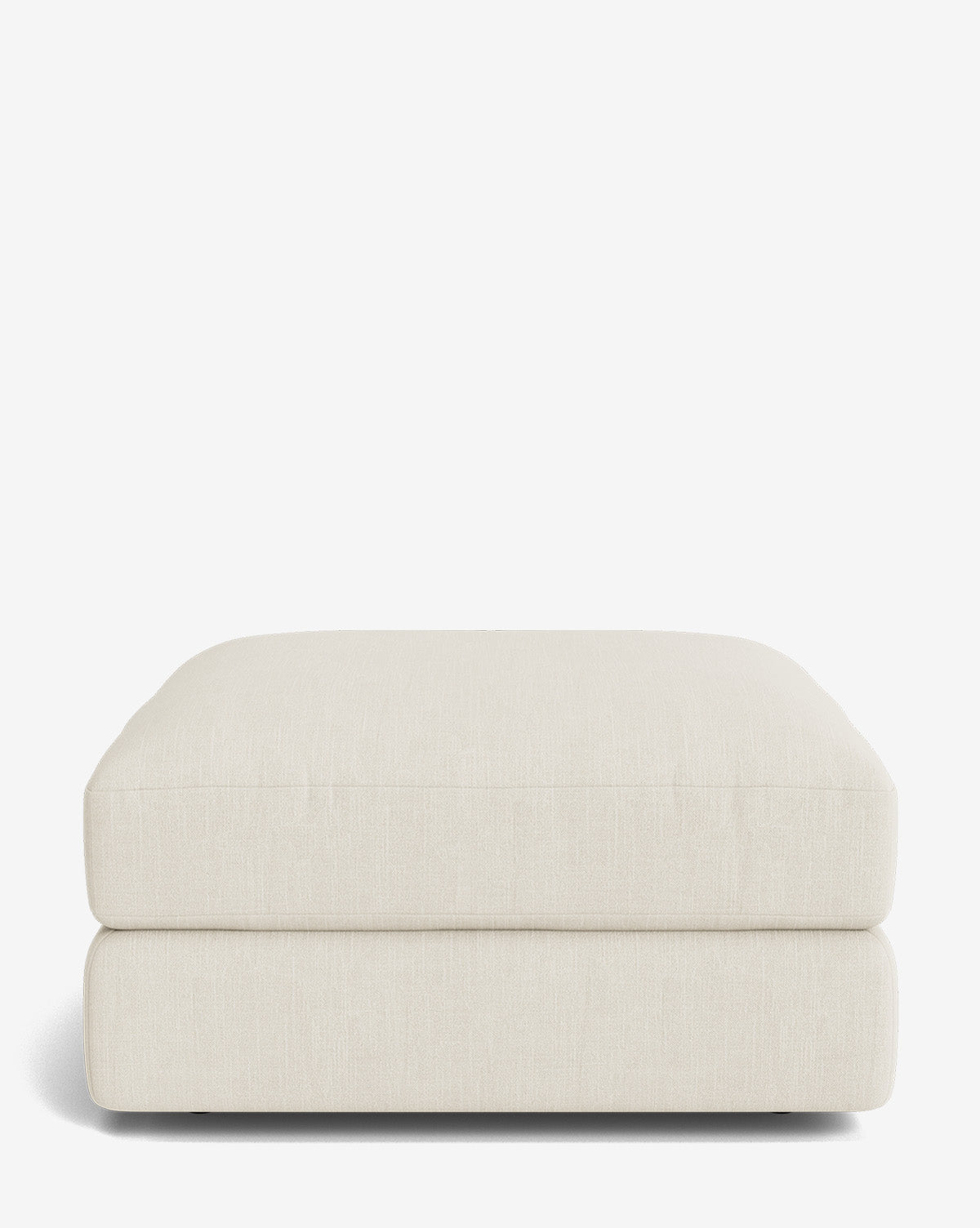 The Makerspalm Claremont Modular Ottoman is a large, square ottoman in light beige fabric with a soft, cushioned top and modern lines, shown on a plain white background. Vendixs