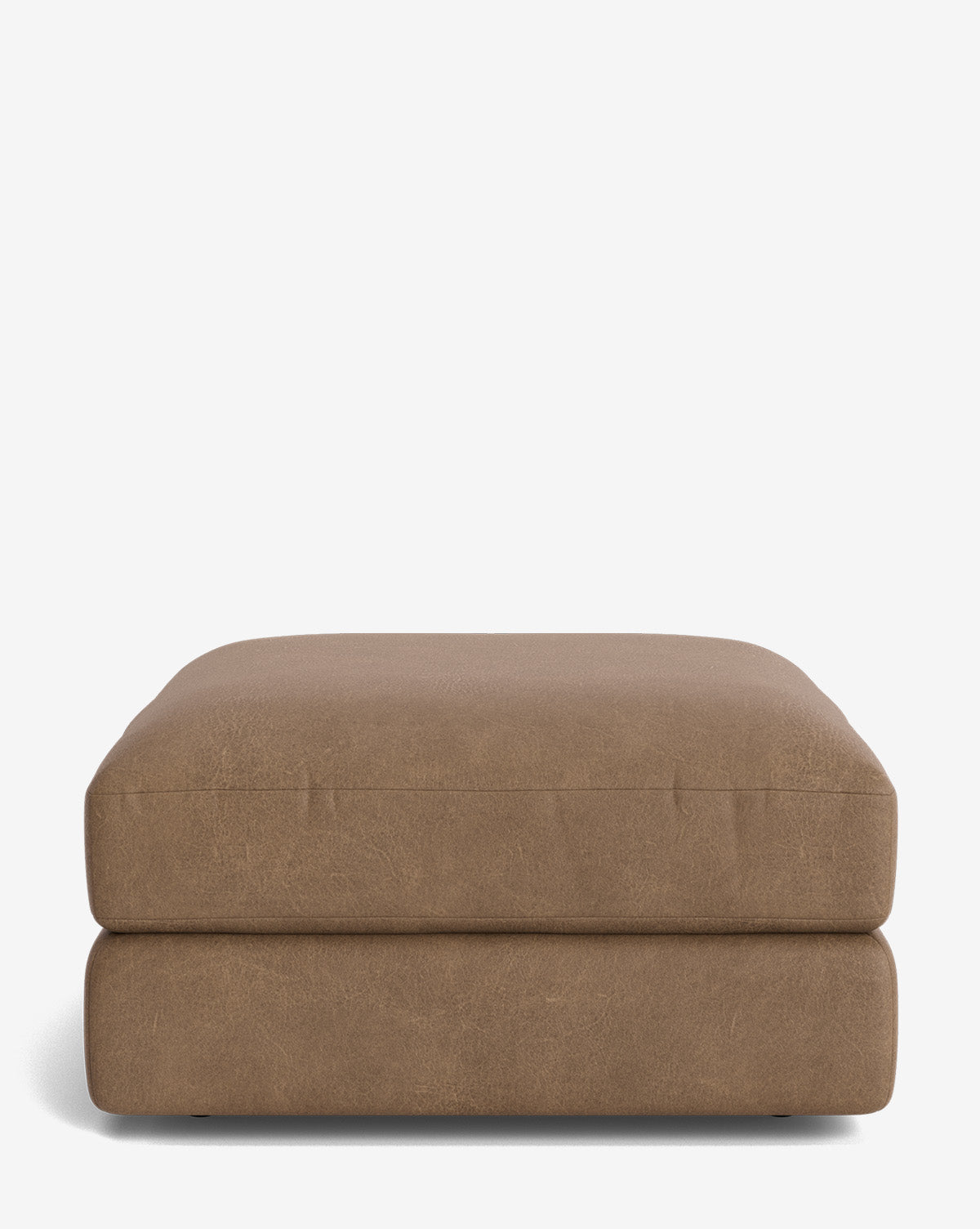 The Claremont Modular Ottoman by Makerspalm features a square shape, brown vintage-inspired smooth leather, and softly rounded edges, displayed on a plain white background. Vendixs