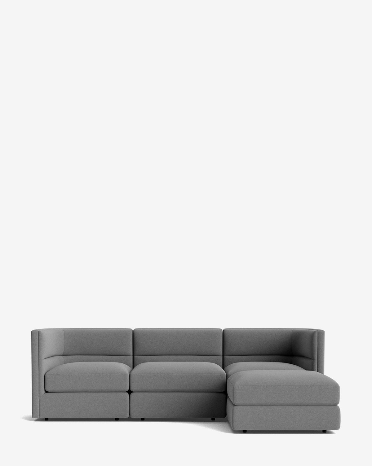 The Makerspalm Claremont Modular Sofa with Ottoman 99 is a modern gray L-shaped design with three seat cushions and a right-side chaise, shown against a plain white background. Vendixs