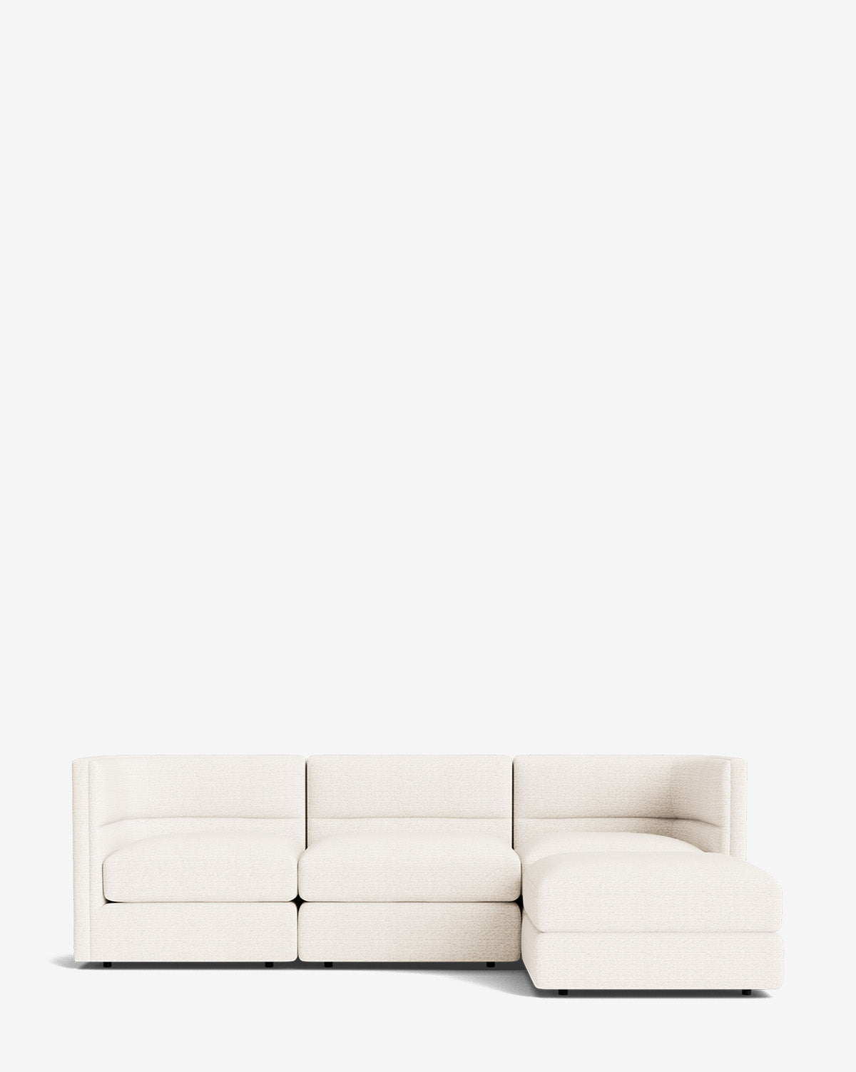 The Makerspalm Claremont Modular Sofa with Ottoman 99 is a modern, low-profile off-white piece featuring three seats and a right-side chaise, shown against a plain white background. Vendixs