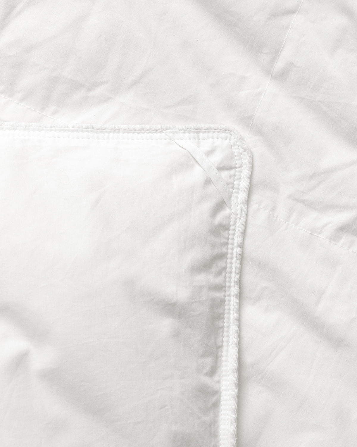 Close-up of a white quilted jacket with a focus on the stitching detail from Vendixs