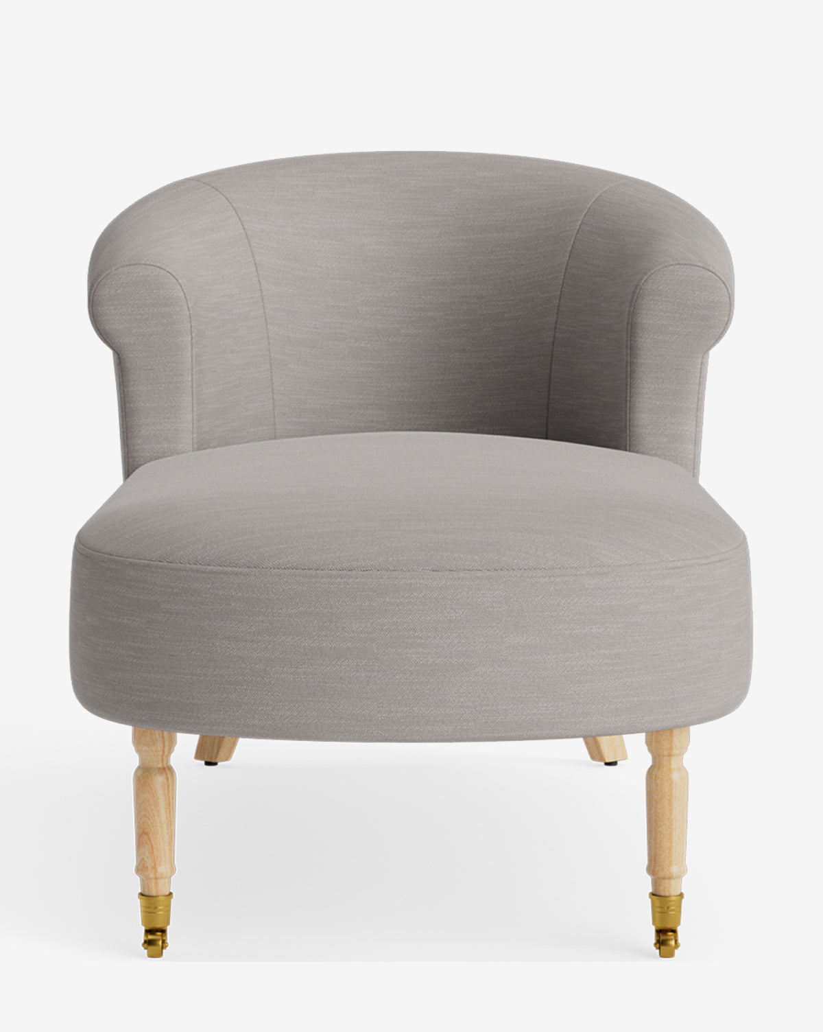 The Clemence Chaise features light gray upholstery, a curved backrest, and light wooden legs with brass casters, offering customizable comfort by McGee & Co. Shown against a plain white background.