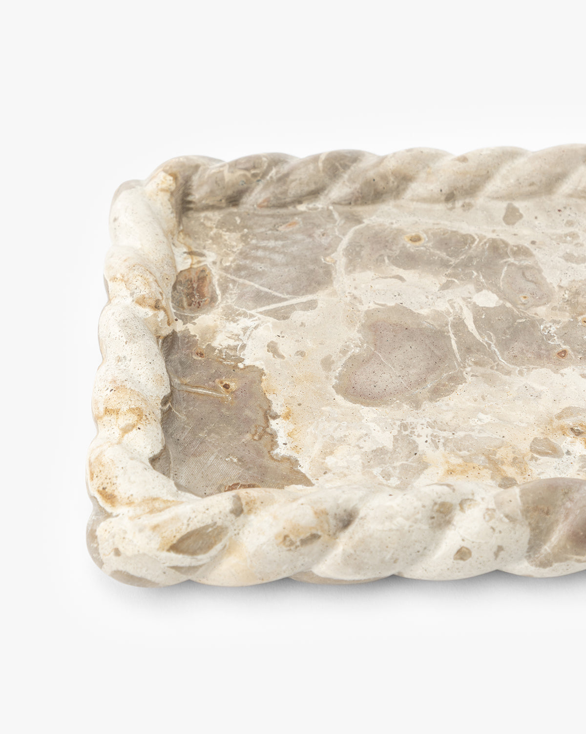 A close-up of the Cleves Marble Tray, a rectangular marble tray with twisted rope-like edges and natural beige and gray stone patterns. Ideal as a decorative tray or vanity organizer, shown against a white background, by Vendixs