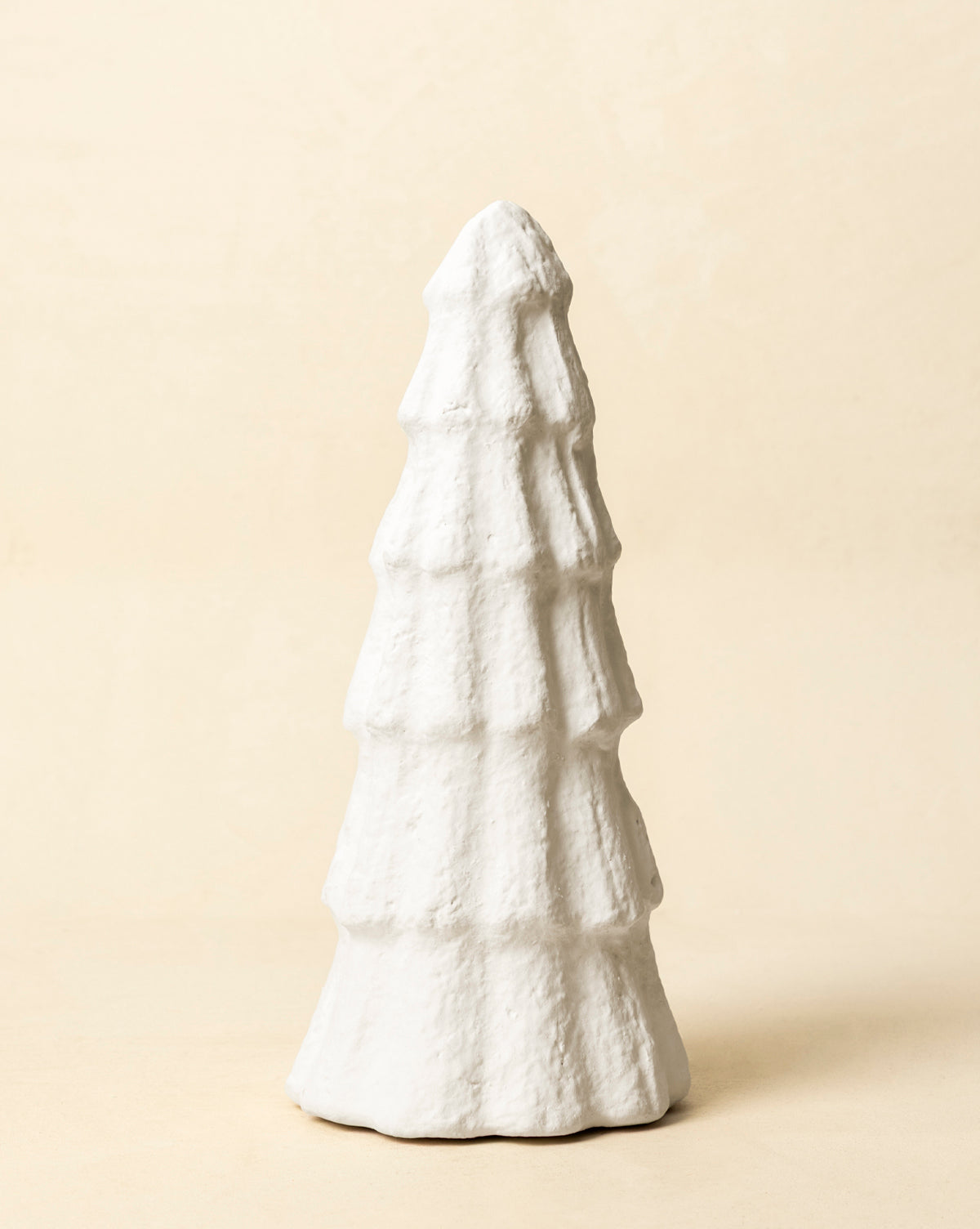 The Confectioners Paper Mache Tree is a handcrafted white decoration with a textured, layered design, perfect for adding elegant holiday style to any neutral setting, by Vendixs