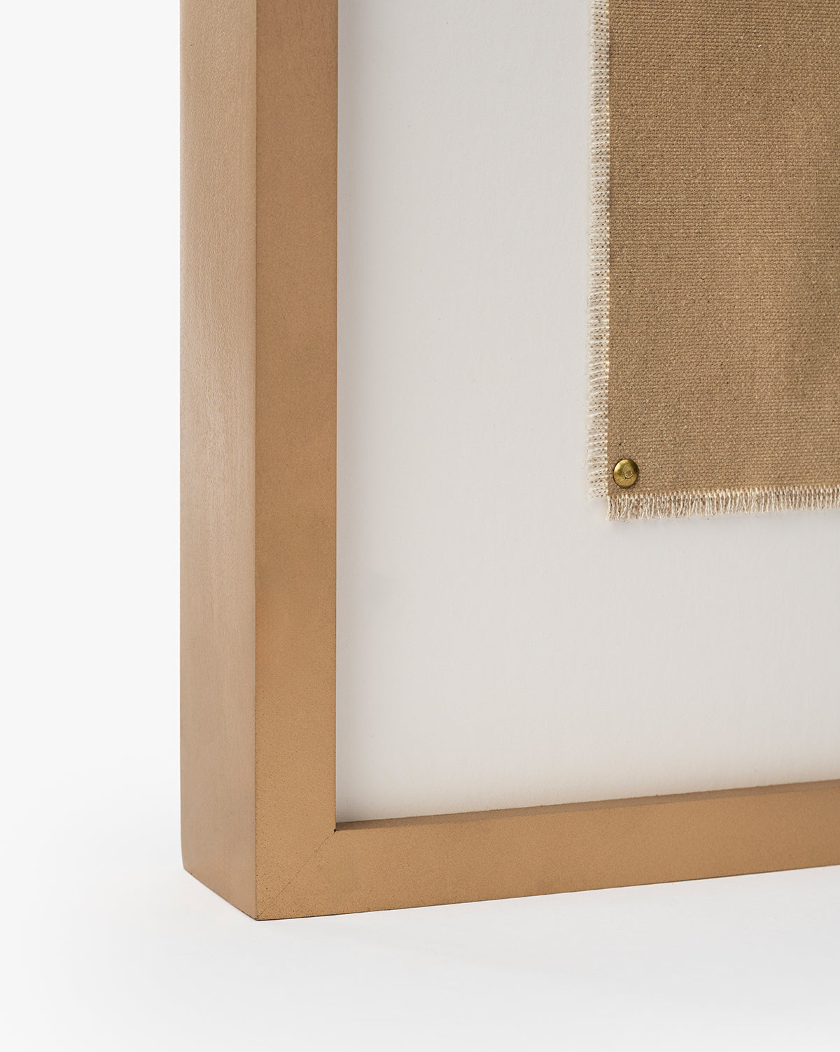 A close-up of Consider the Wildflowers by Katie Mulder, a beige fabric artwork held in a gold-colored maple frame and secured with a round brass tack against a white background, by Vendixs