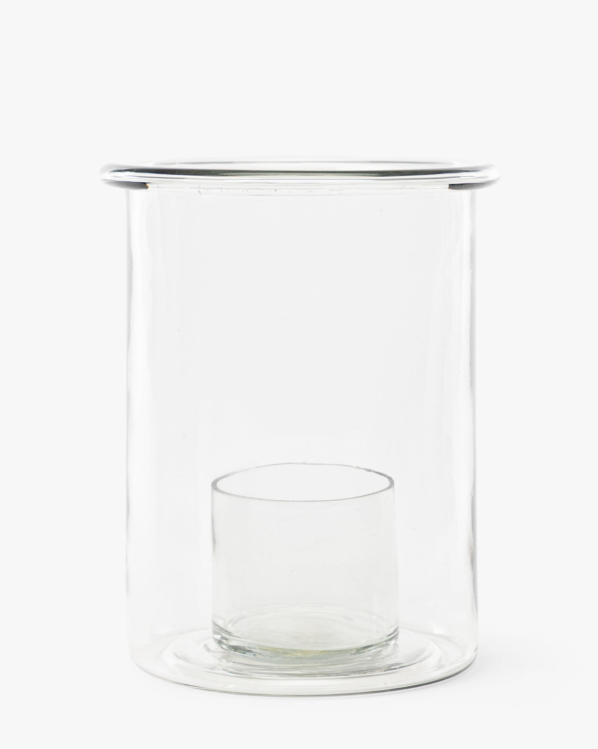 The Cyrus Hurricane is a clear glass candle holder with a cylindrical outer vessel and an inner glass holder at the base, perfect for adding modern elegance to your home decor, by Vendixs