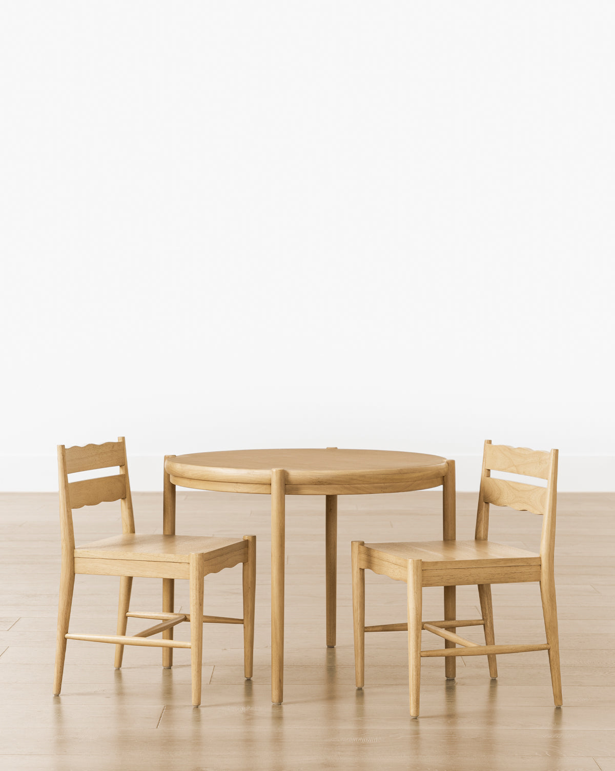 The Darcy Kids Table is arranged with two simple white oak chairs on a light wood floor against a plain white background, by Vendixs