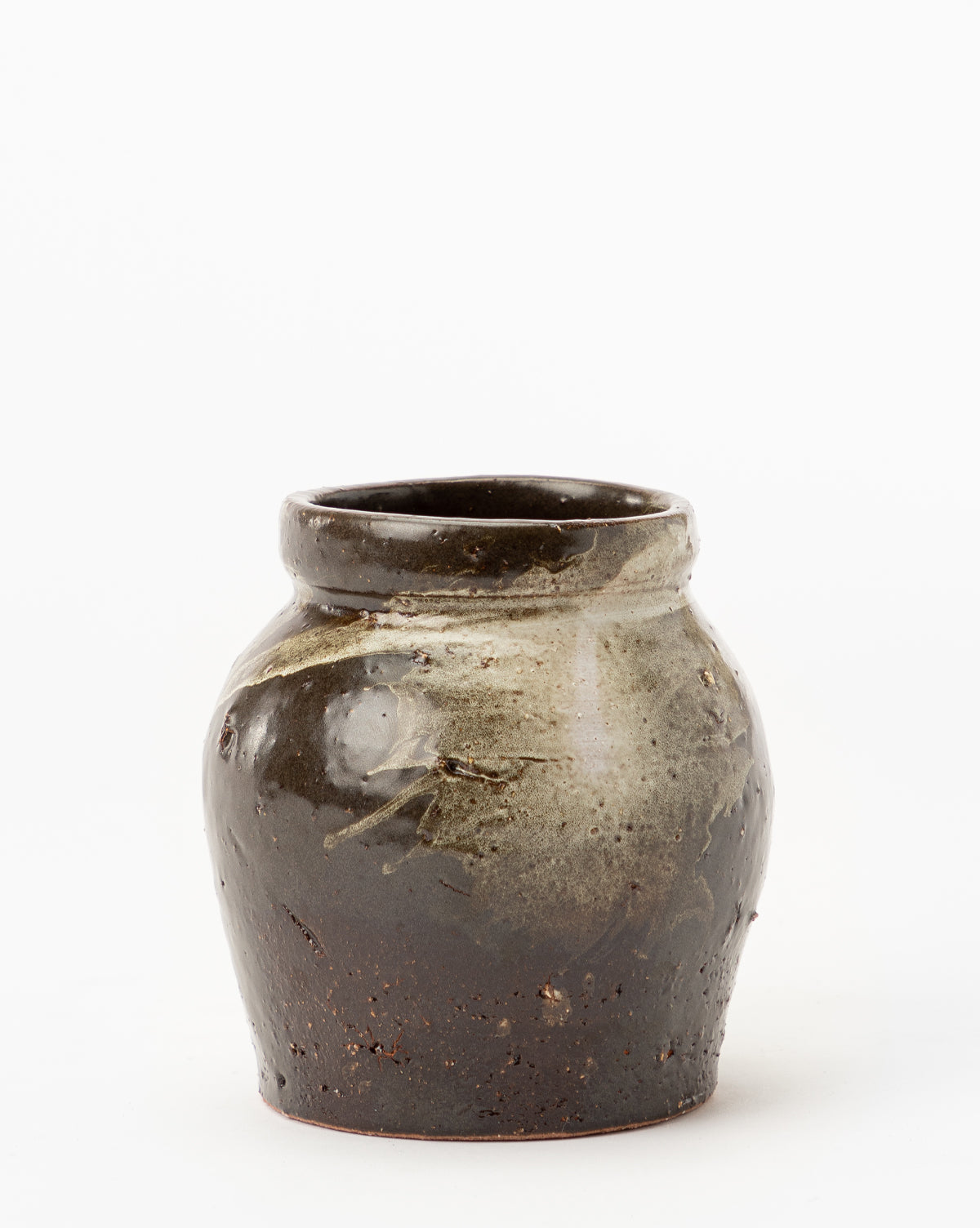 The Dark Glazed Ceramic Vase features a rustic, dark brown, glossy finish with an uneven rounded shape and lighter glaze drips near the top, creating a classic ceramics look that stands out against a white background.