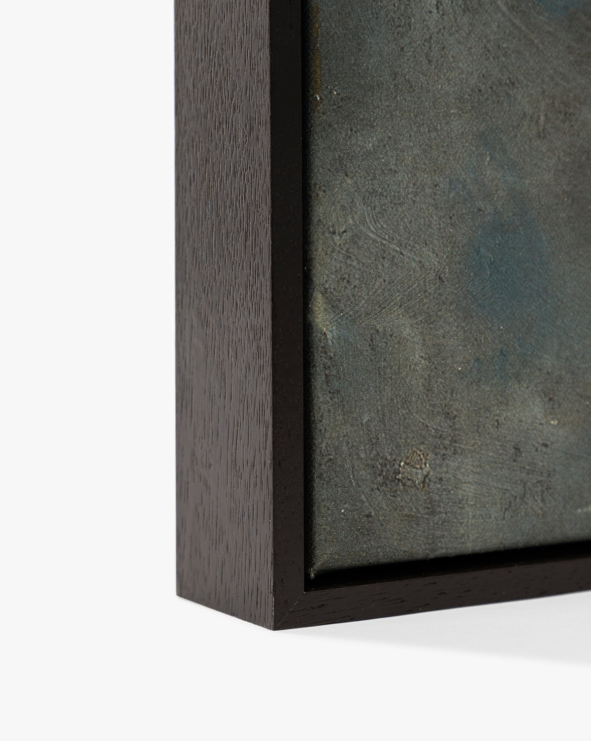 Close-up of the corner of a dark floater frame with an espresso finish, highlighting the edge and part of Dark Skies Ahead, a textured blue-gray abstract giclée canvas, by Vendixs