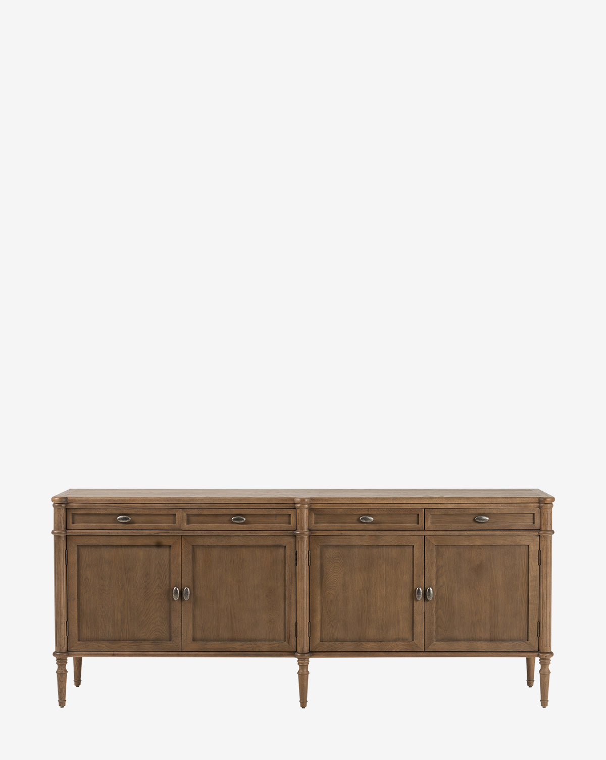 The Dixon Sideboard features four front doors, four drawers, and aged brass hardware, by McGee & Co. This oak sideboard stands on six tapered legs and is showcased against a plain white background.