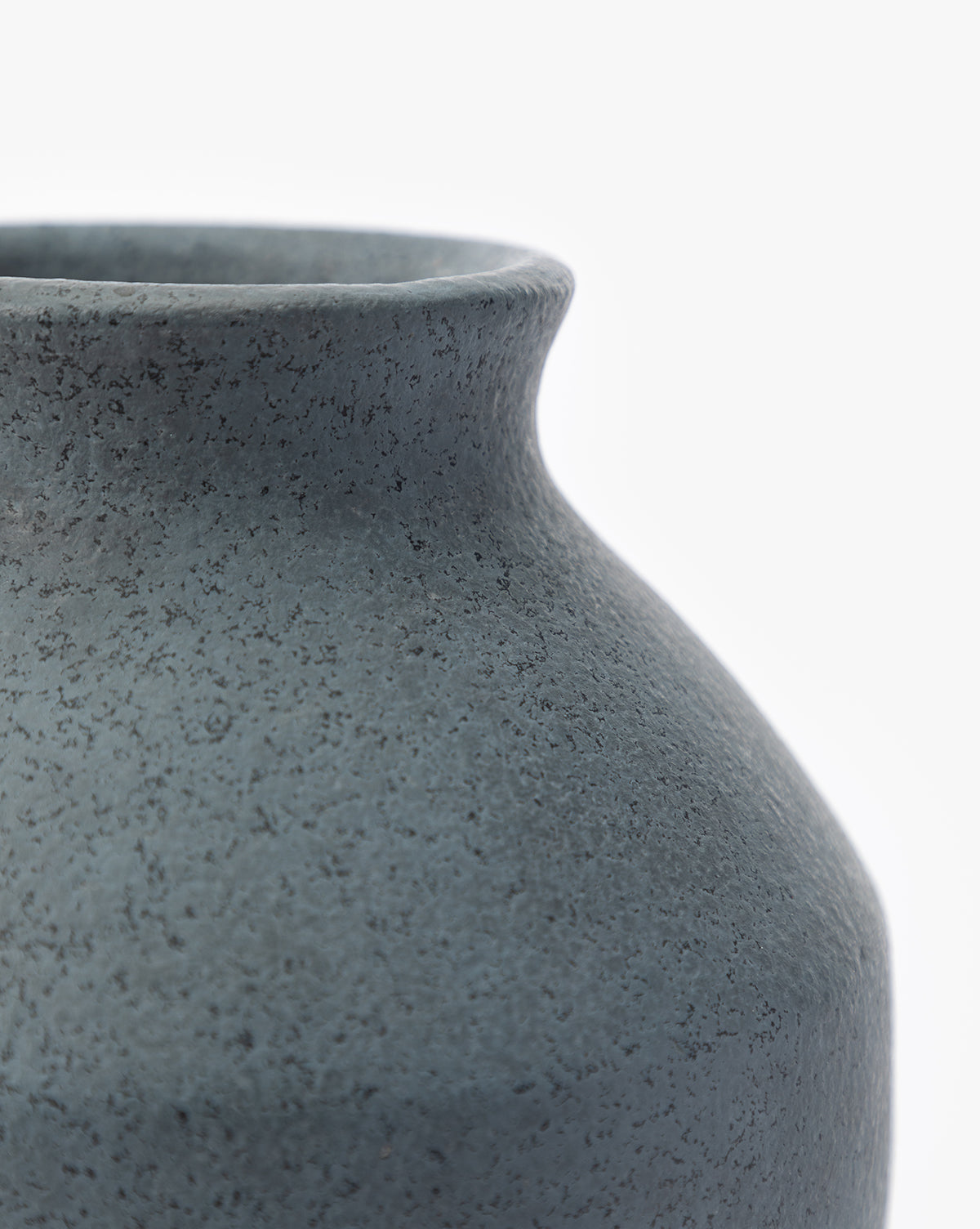 Close-up of the Delgado Vase, featuring its textured matte dark gray surface, with a focus on the round body and narrow neck set against a plain white background, by Vendixs