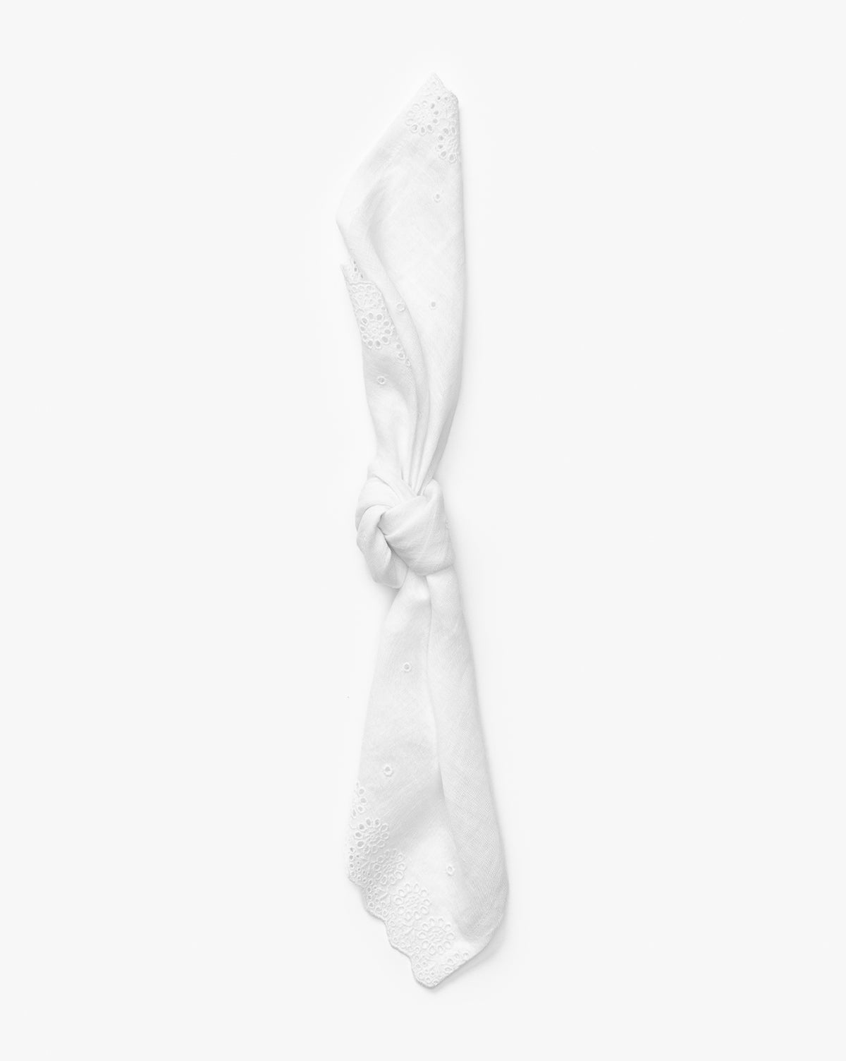 The Vendixs x Loeffler Randall Delilah Broderie Napkin, shown neatly knotted at the center, features a delicate broderie border and is displayed against a plain white background by Vendixs