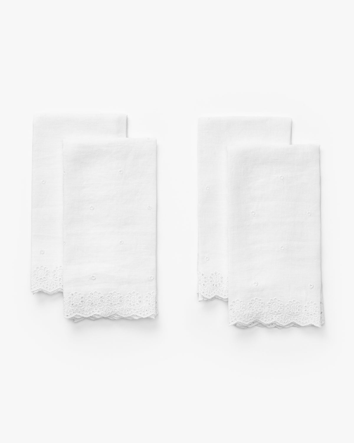 The Vendixs x Loeffler Randall Delilah Broderie Napkins (Set of 4) are white linen with delicate embroidery, broderie borders, and scalloped lace edges, neatly folded in pairs against a plain white background by Vendixs