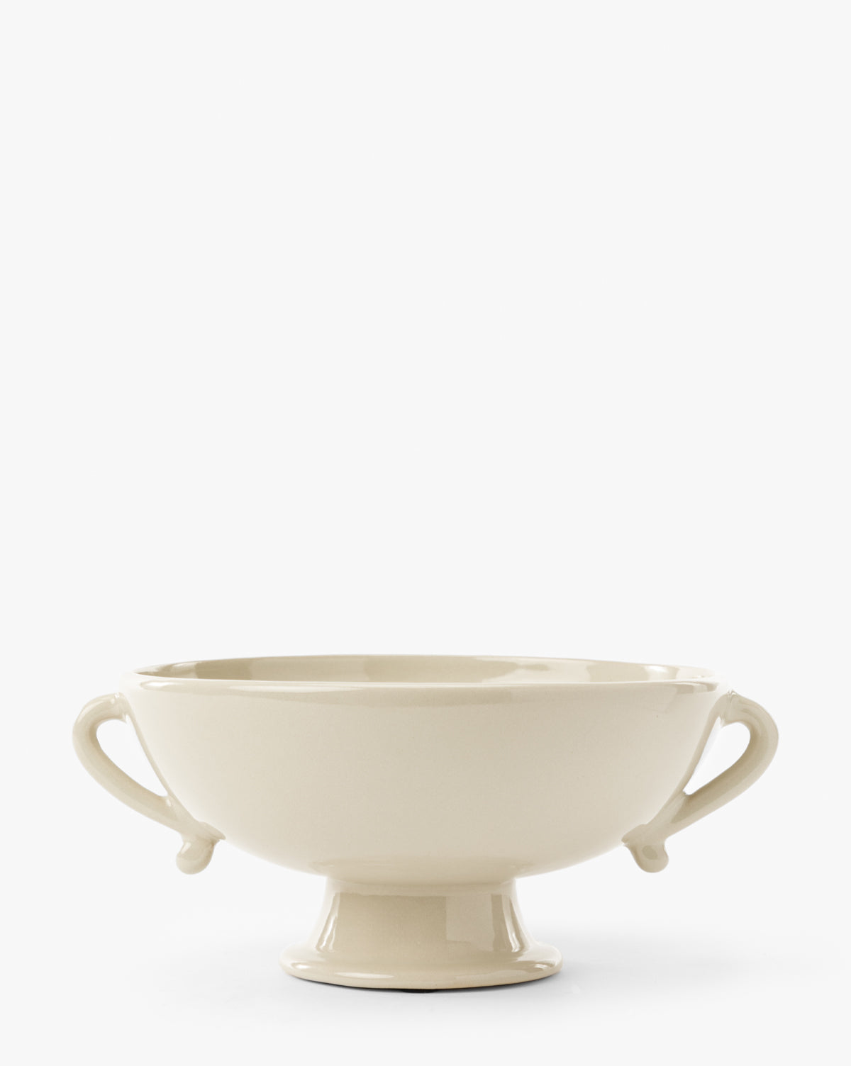 The Delphine Footed Bowl is a cream-colored ceramic piece featuring two curved side handles and a pedestal base, displayed against a plain white background, by Vendixs