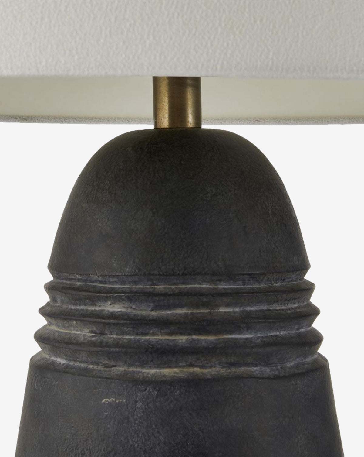 Close-up of the Django Table Lamp, showcasing its textured dark terracotta base with horizontal ridges, brass-toned rod, and a white linen shade, by Vendixs