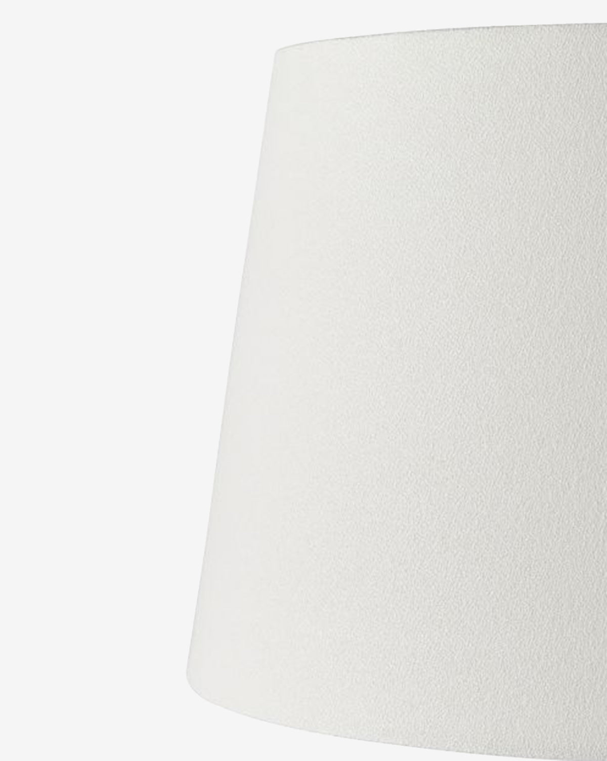 A close-up view of the Django Table Lamp’s plain white linen shade, featuring a subtly textured surface against a white background. Only the upper section and side of the lampshade are visible, by Vendixs