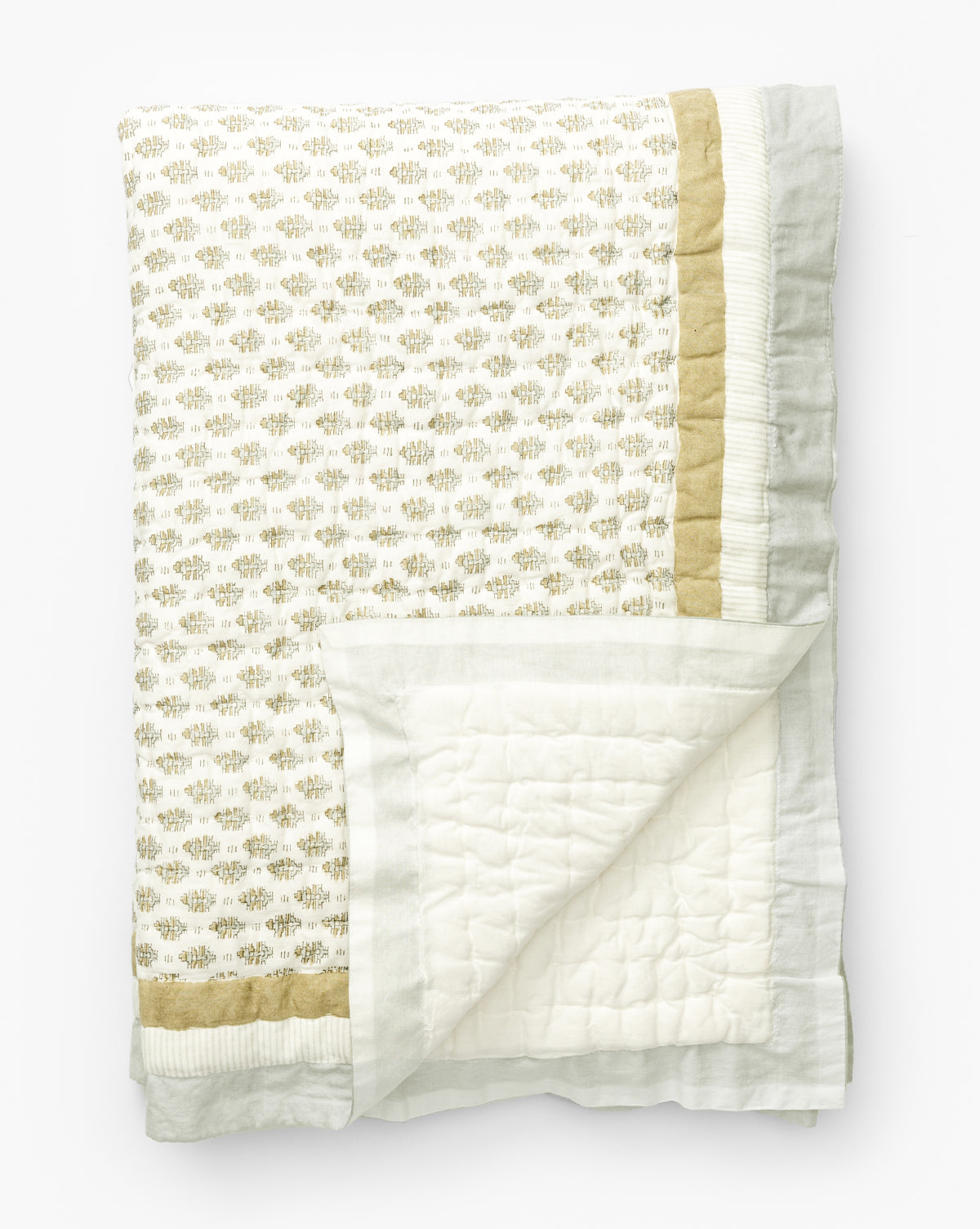 The Dulcie Block Print Kids Quilt by Renuka Inc. is a folded cotton quilt featuring a gold and light gray block print pattern with matching borders; the reverse side is plain white with stitched squares. Vendixs