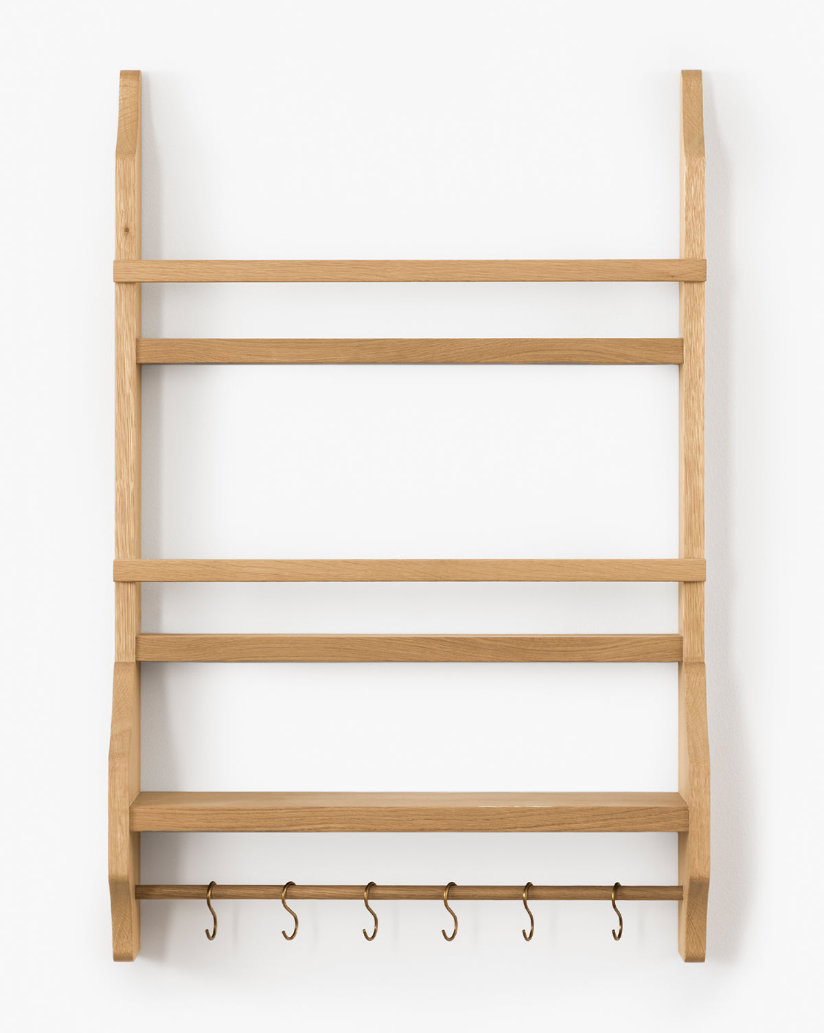 The Edna Kitchen Shelf is a heritage oak wall-mounted unit with four open shelves and five metal hooks underneath, shown against a white background, by Vendixs