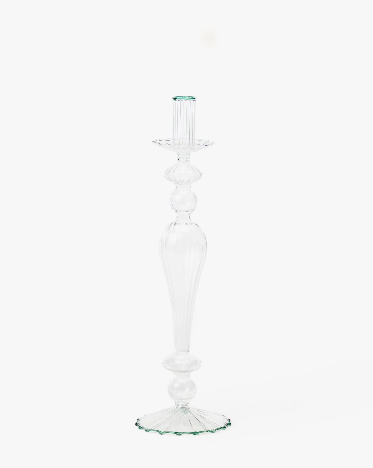The Vendixs x Loeffler Randall Effie Taper Holder is a tall, clear glass holder featuring a fluted design and round base, shown elegantly against a plain white background by Vendixs
