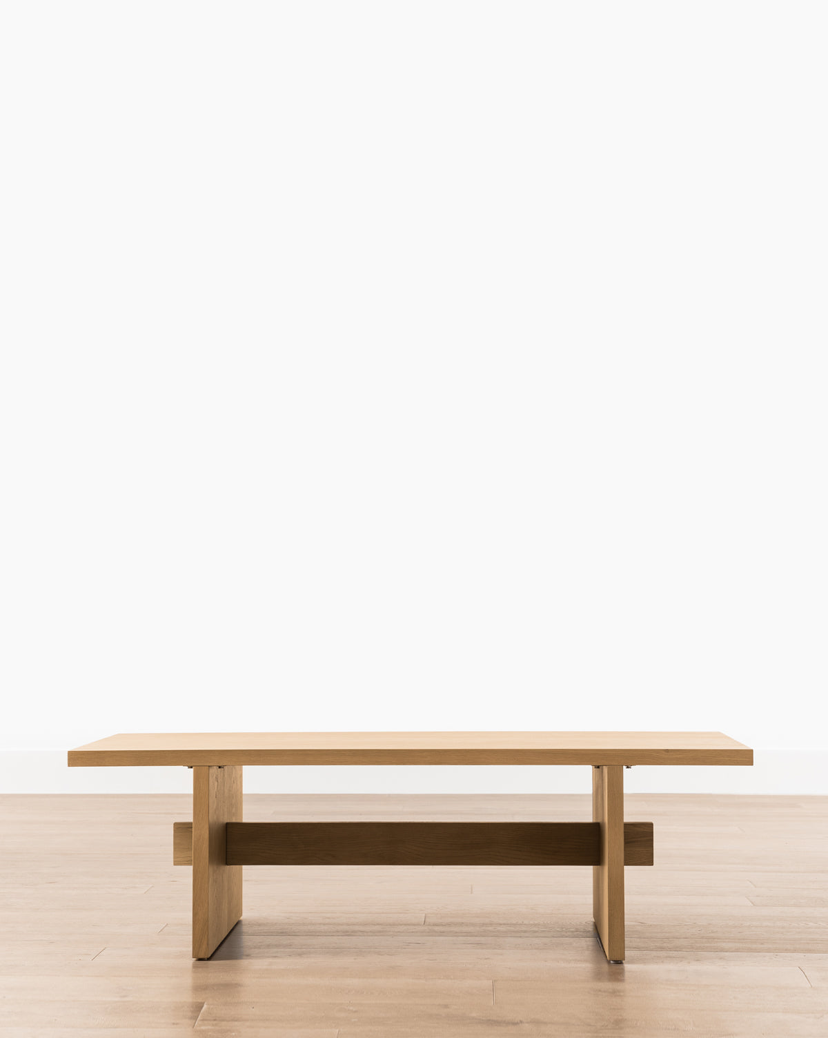 The Eileen Coffee Table showcases a minimalist, modern design with clean lines and a rectangular white oak top, ideal for contemporary spaces, by McGee & Co.