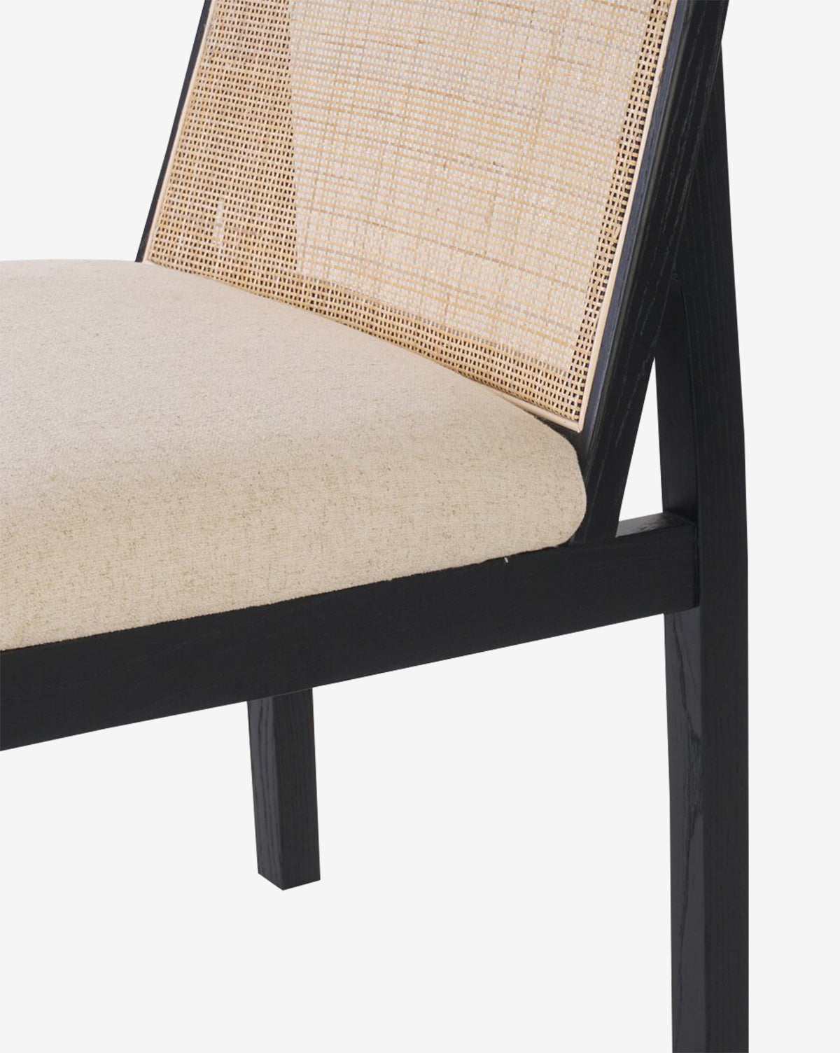 A close-up of the Eira Dining Chair showcasing its black wooden frame, beige performance fabric seat, and elegant cane backrest, set against a plain white background by Vendixs