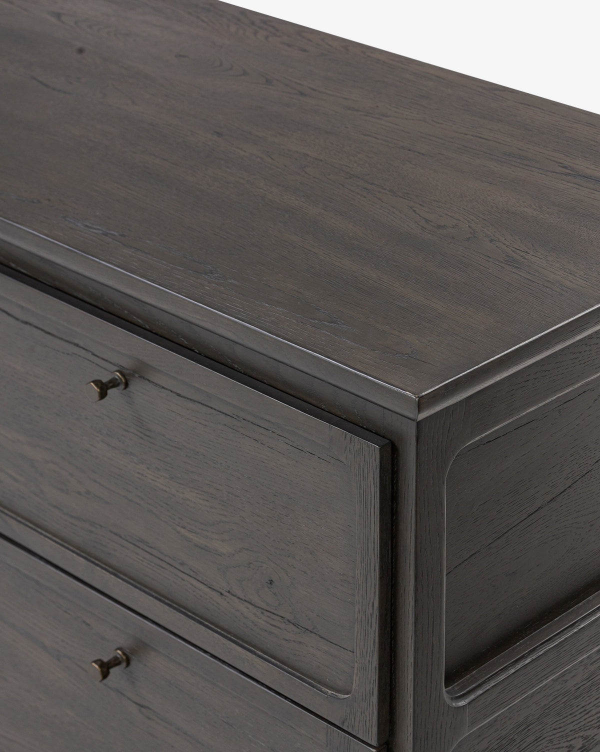 Close-up of the top corner of the Eldoria Oak Sideboard in black with visible grain, two drawers, and small round metal pulls, set against a plain white background—a modern deco accent piece, by Vendixs