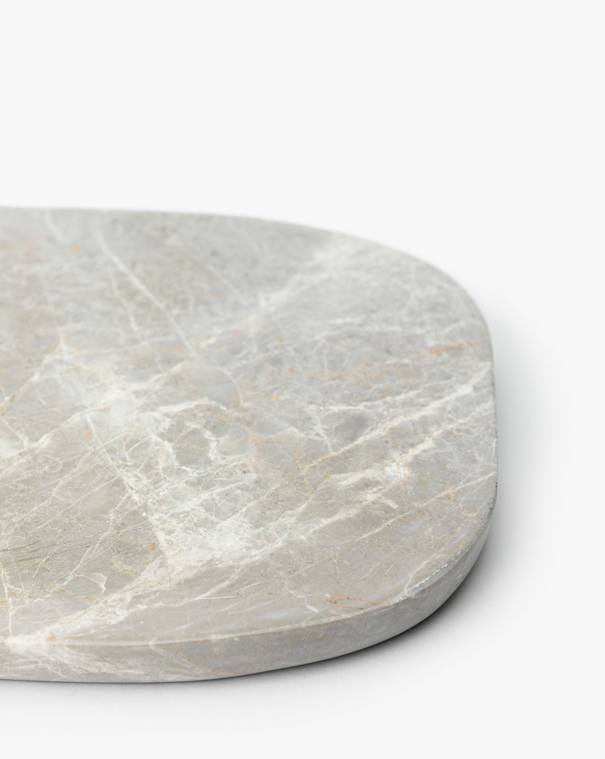 A close-up of the Eliza Marble Tray, a smooth, rounded rectangular decorative piece crafted from light gray marble with white veining, photographed against a plain white background, by Vendixs