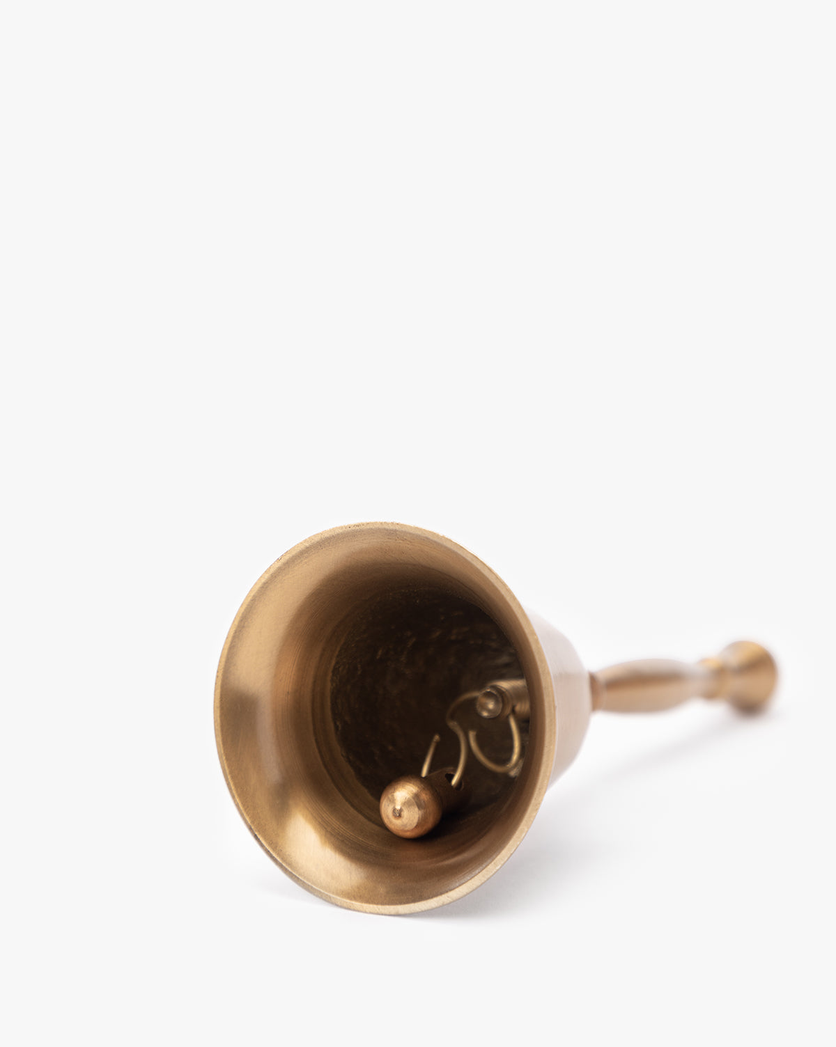 The Elsher Bell, a small antique brass bell with classic styling, rests on its side showing the clapper and handle—perfect for vintage decor against a plain white background, by Vendixs