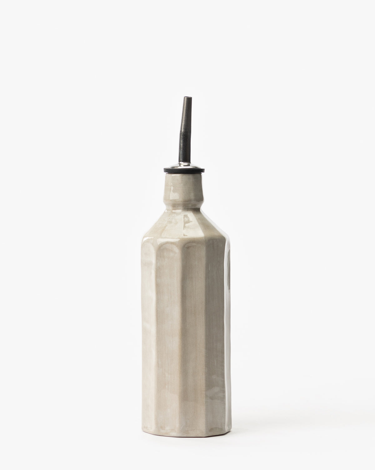 The Emilia Cruet is a tall, beige ceramic bottle with vertical ridges and a metal pour spout—an elegant dispenser for oil or vinegar that enhances any kitchen countertop.