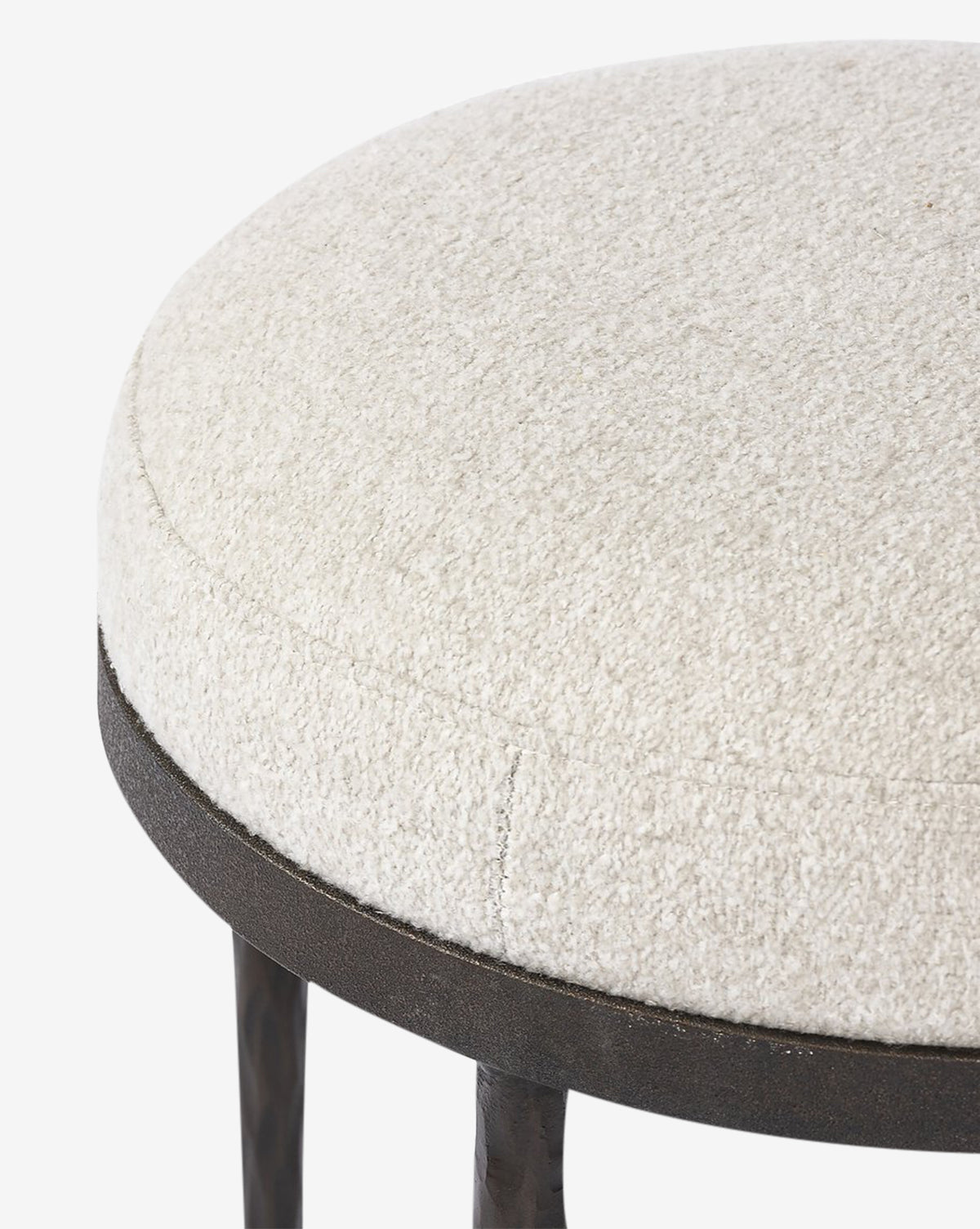 Close-up of the Emmett Stool by Four Hands, featuring a round, textured off-white upholstered seat and a dark metal frame—an ideal accent piece for any space. Vendixs