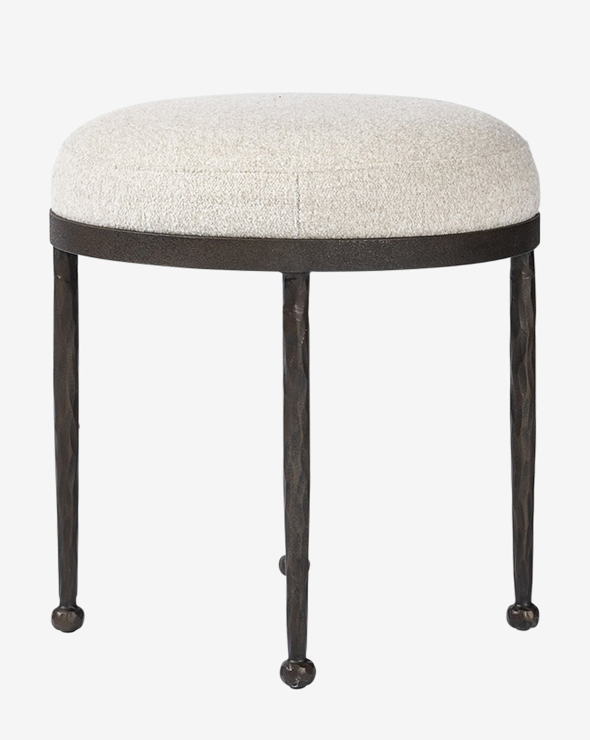 The Emmett Stool by Four Hands features a round, light beige cushioned seat atop three slender black metal legs. Its minimalist design and subtly textured finish bring modern style to any space. Vendixs