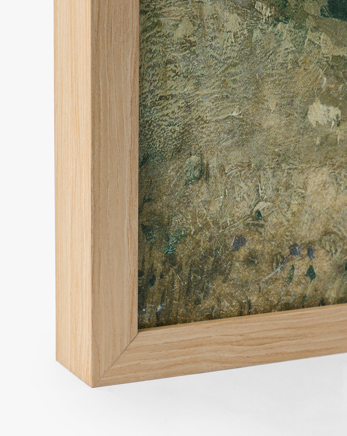 Close-up of the bottom left corner of a natural oak frame with visible wood grain, holding English Meadows, a textured greenish giclee on canvas. The frame features a light natural wood color, by Vendixs
