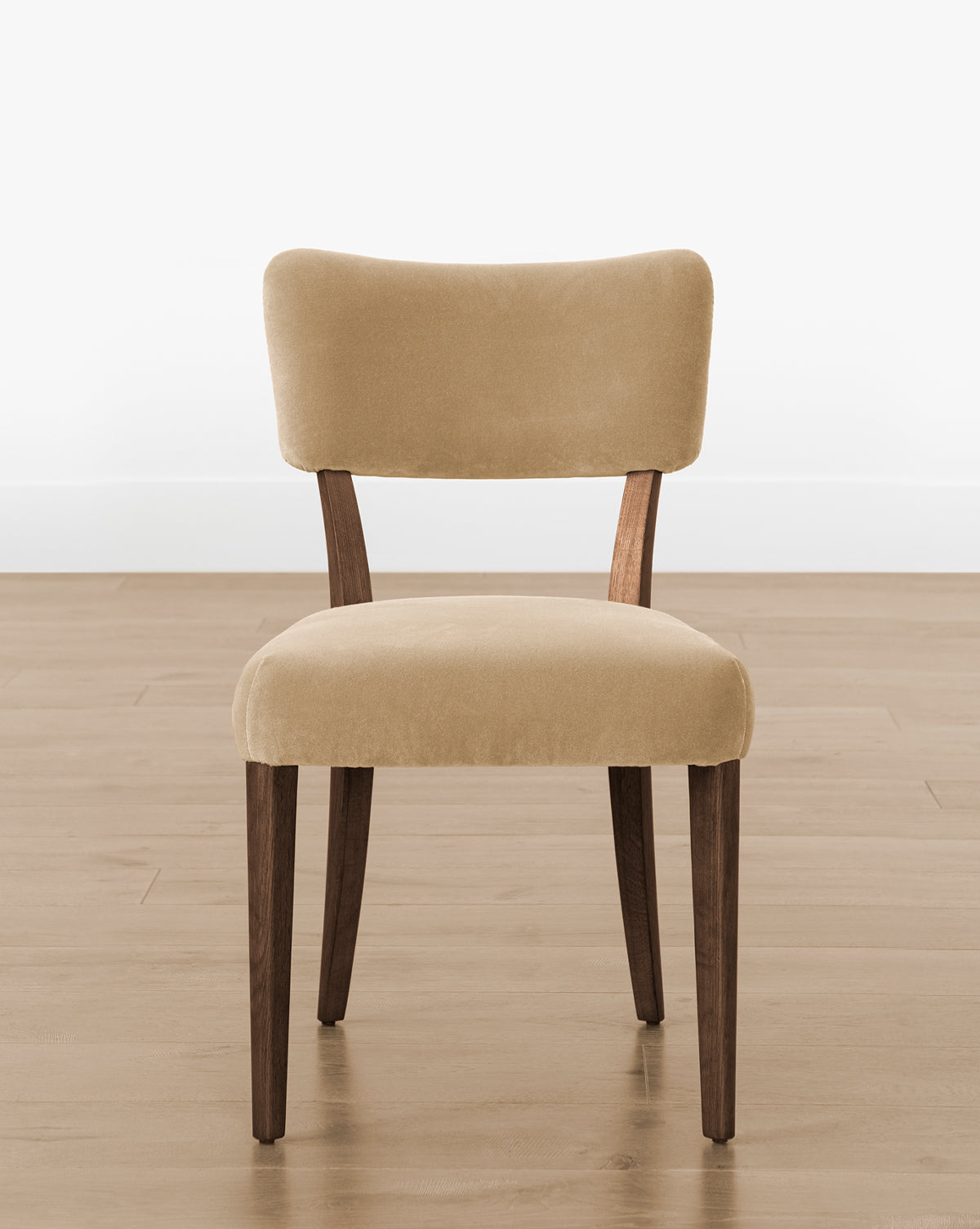 The Makerspalm Etienne Dining Chair (Ready to Ship) offers a light beige upholstered seat and backrest, dark wooden legs, and a minimalist design—ideal for bringing timeless elegance to any space. Vendixs