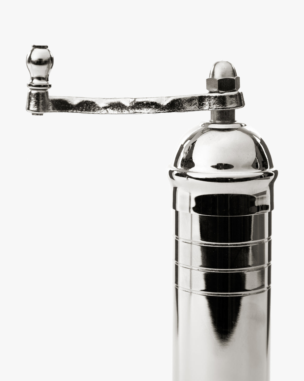 A close-up of the European Chrome Pepper Mill, featuring a shiny chrome finish, a curved hand crank handle, and an adjustable steel grinding mechanism, set against a plain white background, by Vendixs