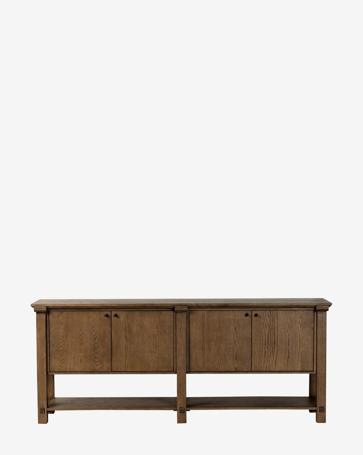 The Evaline Sideboard is a modern solid oak piece with a natural finish, featuring four cabinet doors with round handles and an open bottom shelf, shown against a plain white background by McGee & Co.