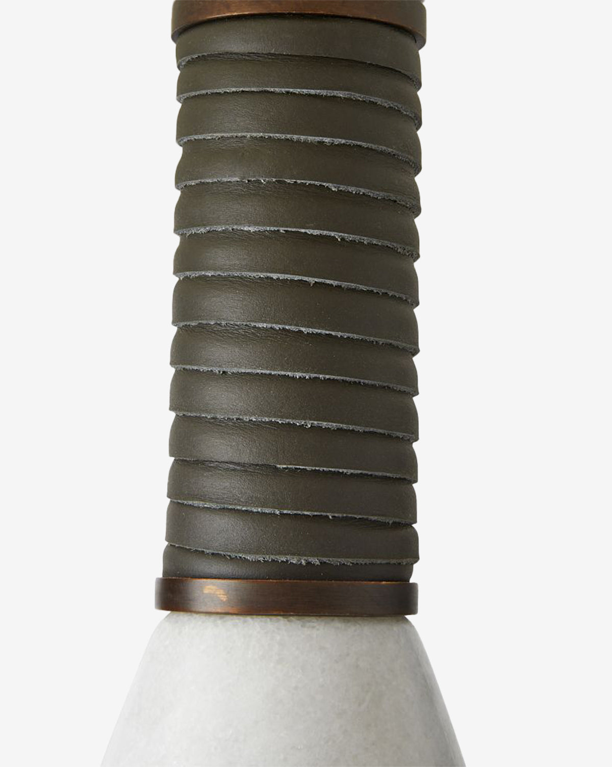 Close-up of the Everly Table Lamp’s dark, ribbed leather-wrapped handle attached to a smooth, conical white marble base. The image focuses on the unique texture and design details of the lamp’s handle, by Vendixs