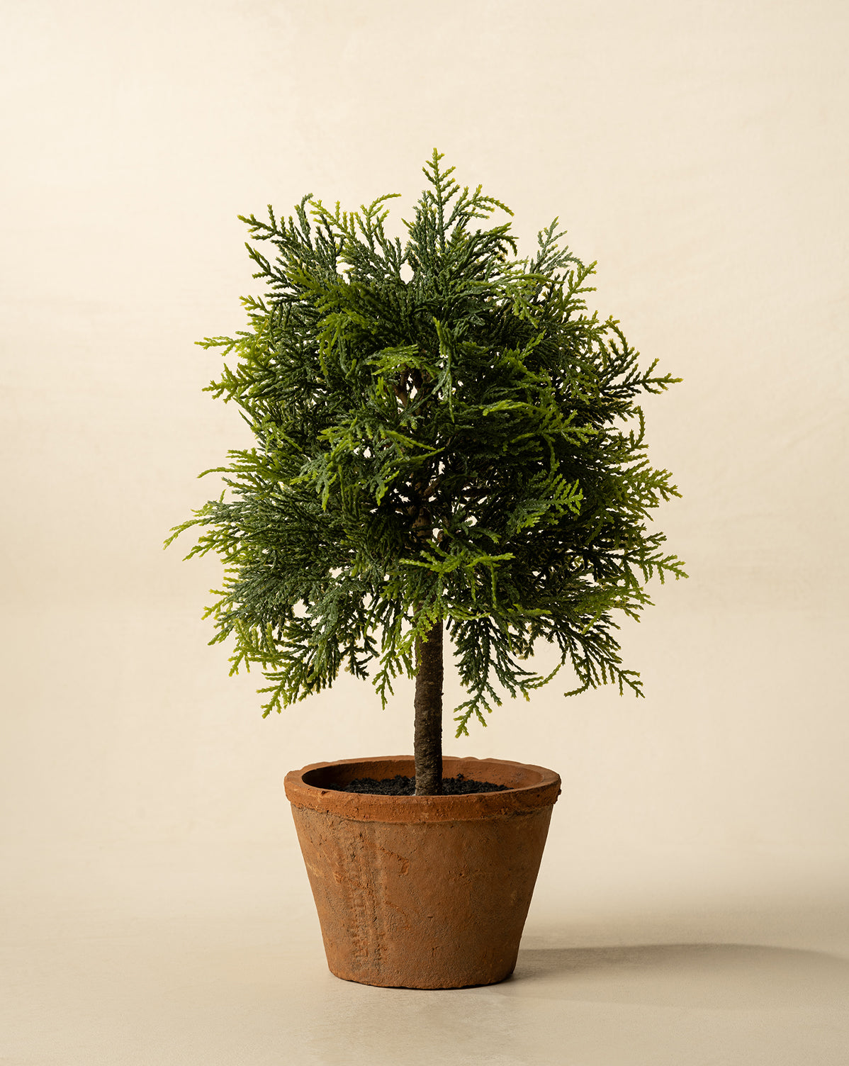 The 15.5" Cypress Faux Potted Topiary features dense, needle-like green foliage in a simple brown terracotta pot, displayed against a plain light background, by Vendixs
