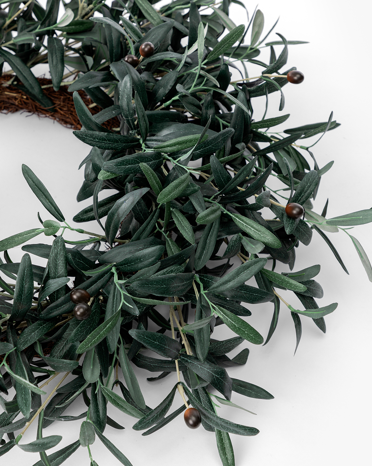 A close-up of the Faux Olive Berry Wreath, showcasing lifelike dark green artificial olive leaves and small round brown berries against a white background, by Vendixs