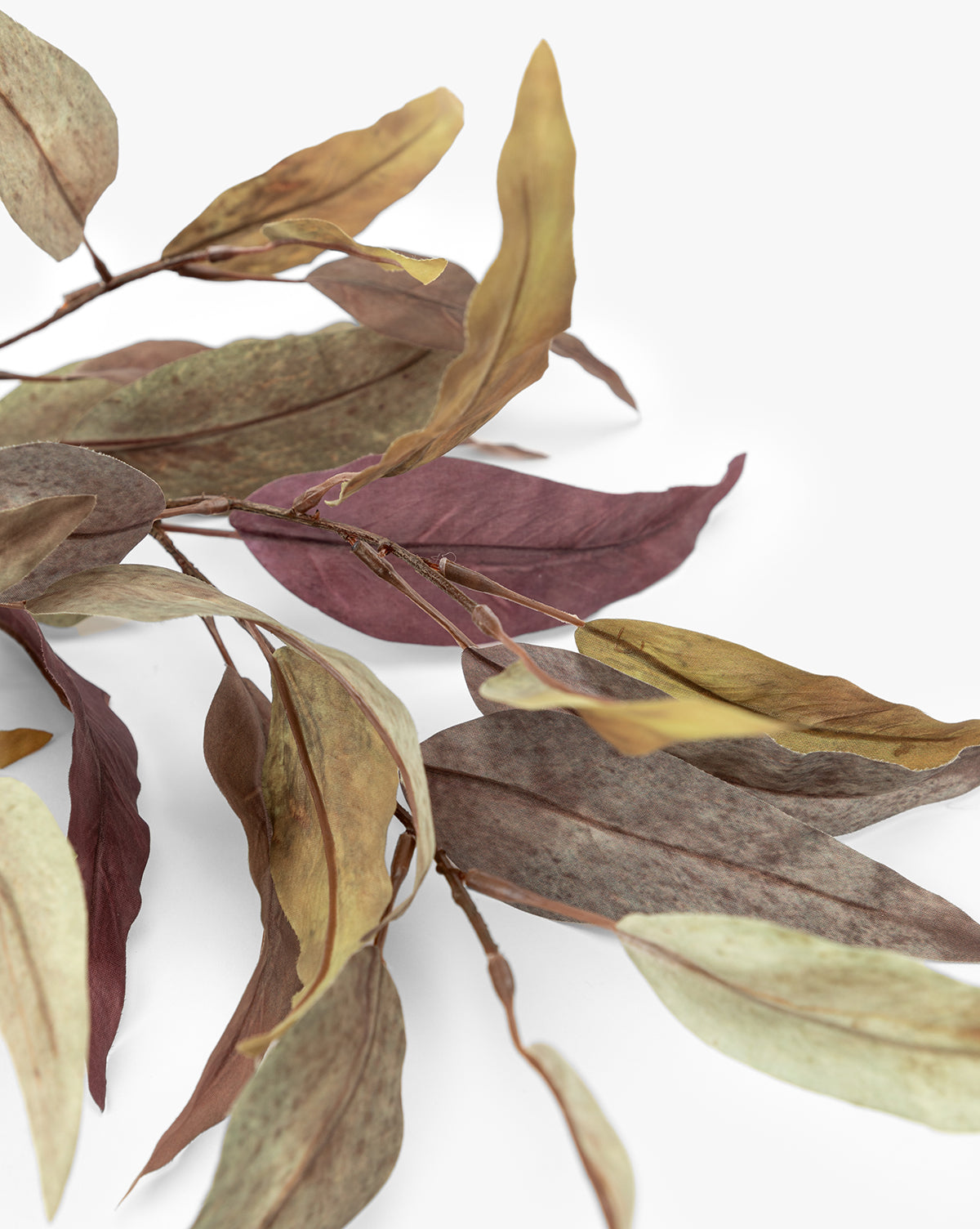 A close-up of the Faux Purple Eucalyptus Stem displays dried eucalyptus leaves in brown, green, and purple tones against a white background—highlighting its lifelike texture, perfect for seasonal centerpieces or as an accent, by Vendixs