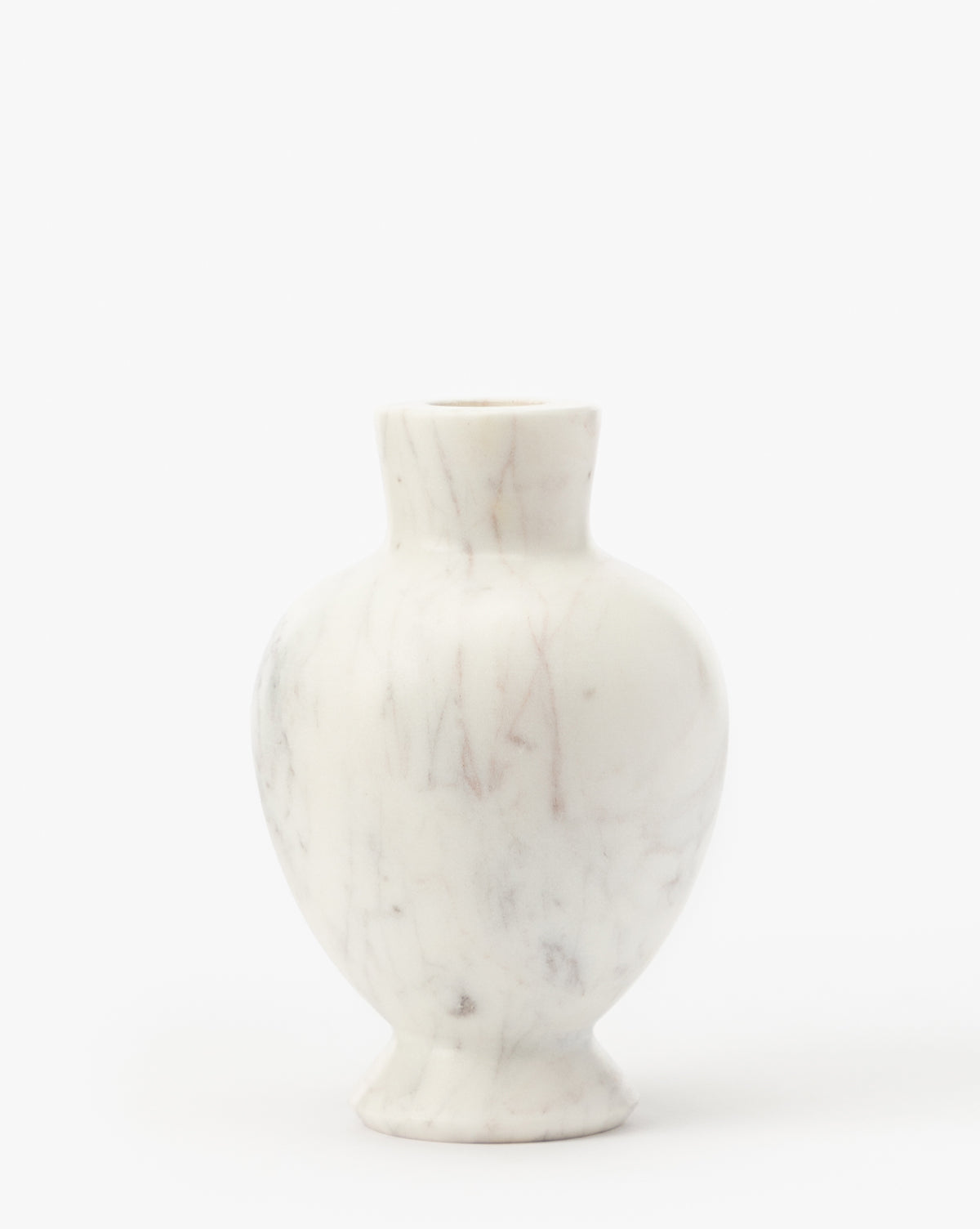 The Fera Bud Vase is a small, white marble vase featuring a rounded body, narrow neck, and subtle gray veining, displayed against a plain white background, by Vendixs
