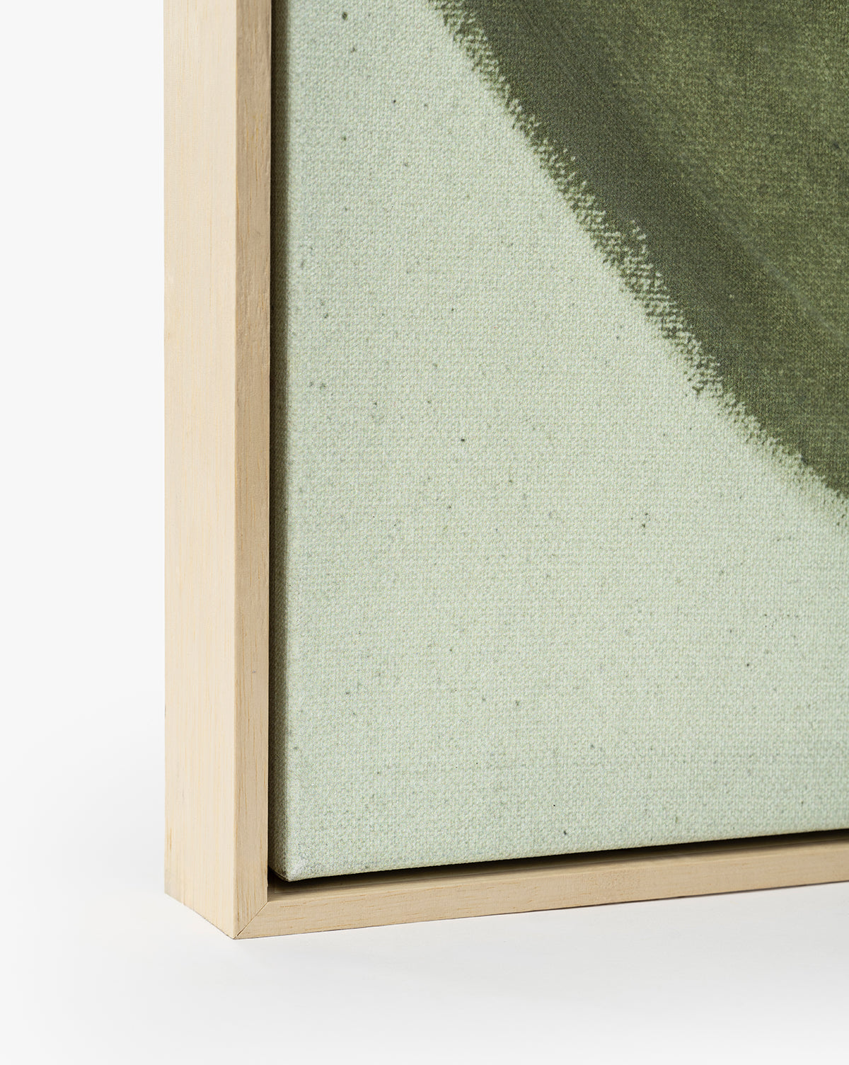 Close-up of the light wood frame on Fields of Green canvas wall art, showcasing abstract green and beige artwork with soft, textured brushstrokes. The canvas edge fits neatly within the frame, by McGee & Co.