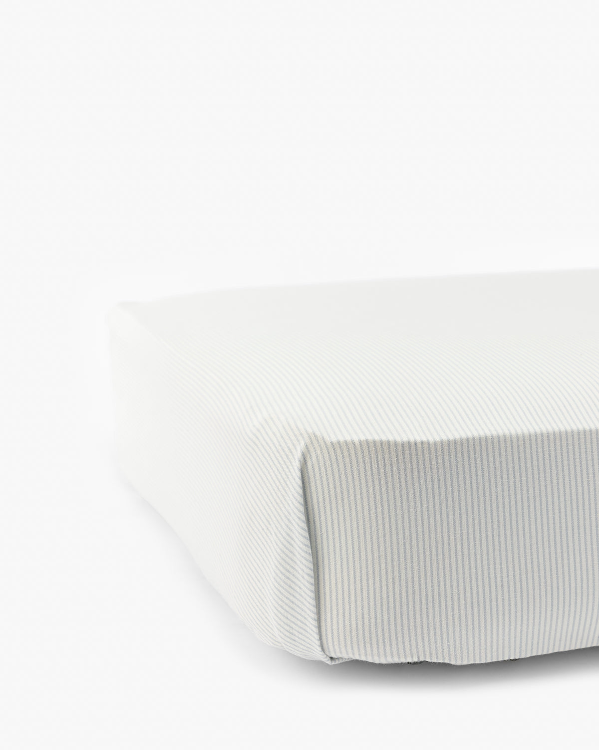 Close-up of a neatly made bed with the Fulton Stripe Crib Sheet, showcasing subtle light grey and white pinstripes on soft, smooth fabric. Ideal for childrens bedding, set against a plain white background by Vendixs