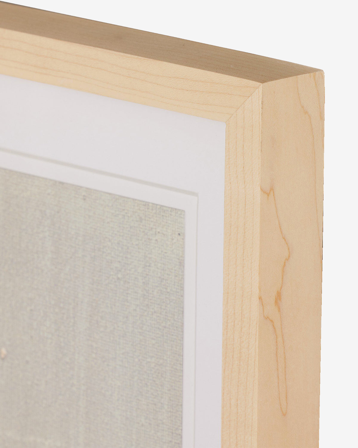 Close-up of the top right corner of a light wood frame holding Galactic VIII by Jade Dacay, showing a white mat and part of the textured mixed media artwork, by Vendixs