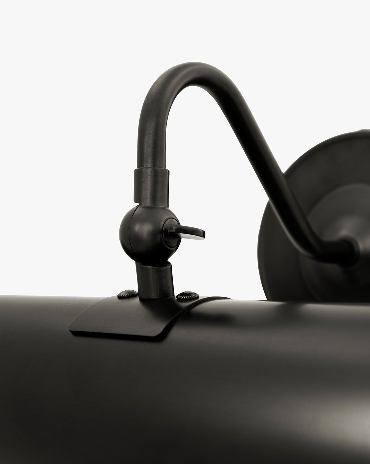 Close-up of the Gallery Picture Sconce, a vintage-inspired matte black wall-mounted lamp with an adjustable curved arm and cylindrical shade, detailed hardware and screws, set against a plain white background, by Vendixs