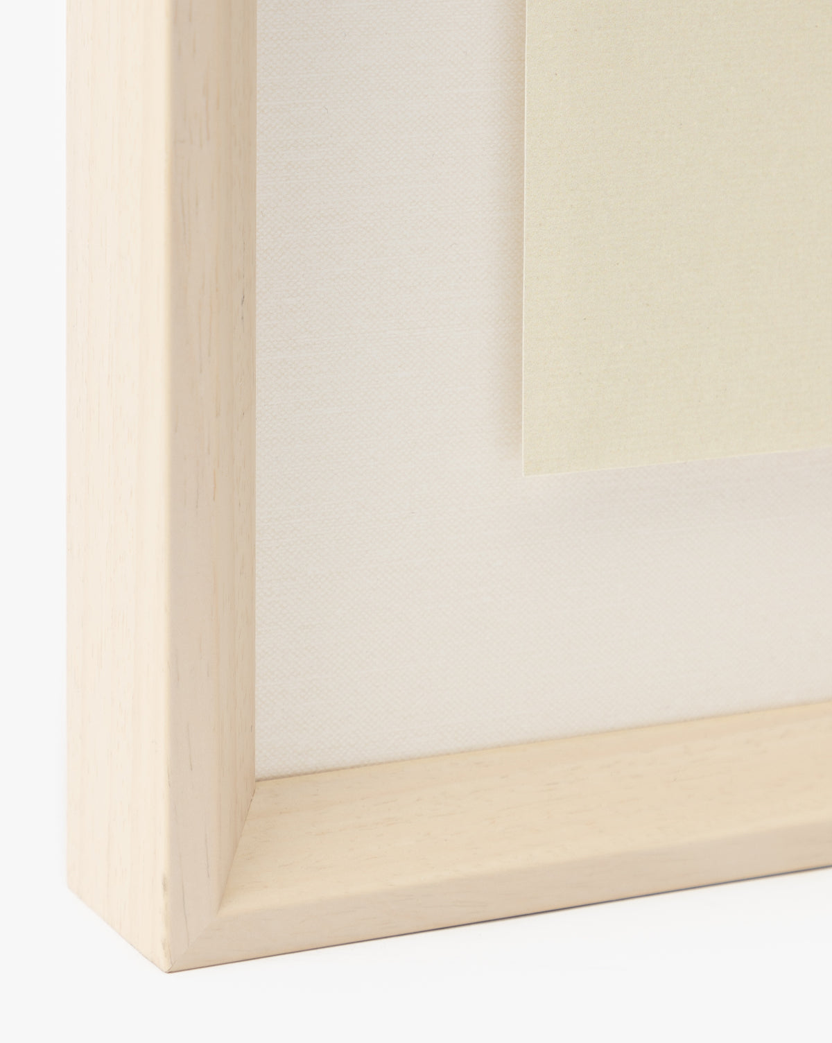 Close-up of a light wood picture frame with a white mat, showcasing the Grape Collage giclee print, featuring beige paper inside the frame against a plain background, by McGee & Co.