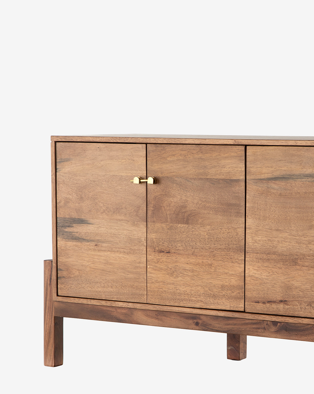 The Gustav Console is a natural-finish wooden sideboard with three doors, a small brass handle on the left door, four sturdy legs, and built-in media cord management—ideal as a mid-century console, by Vendixs