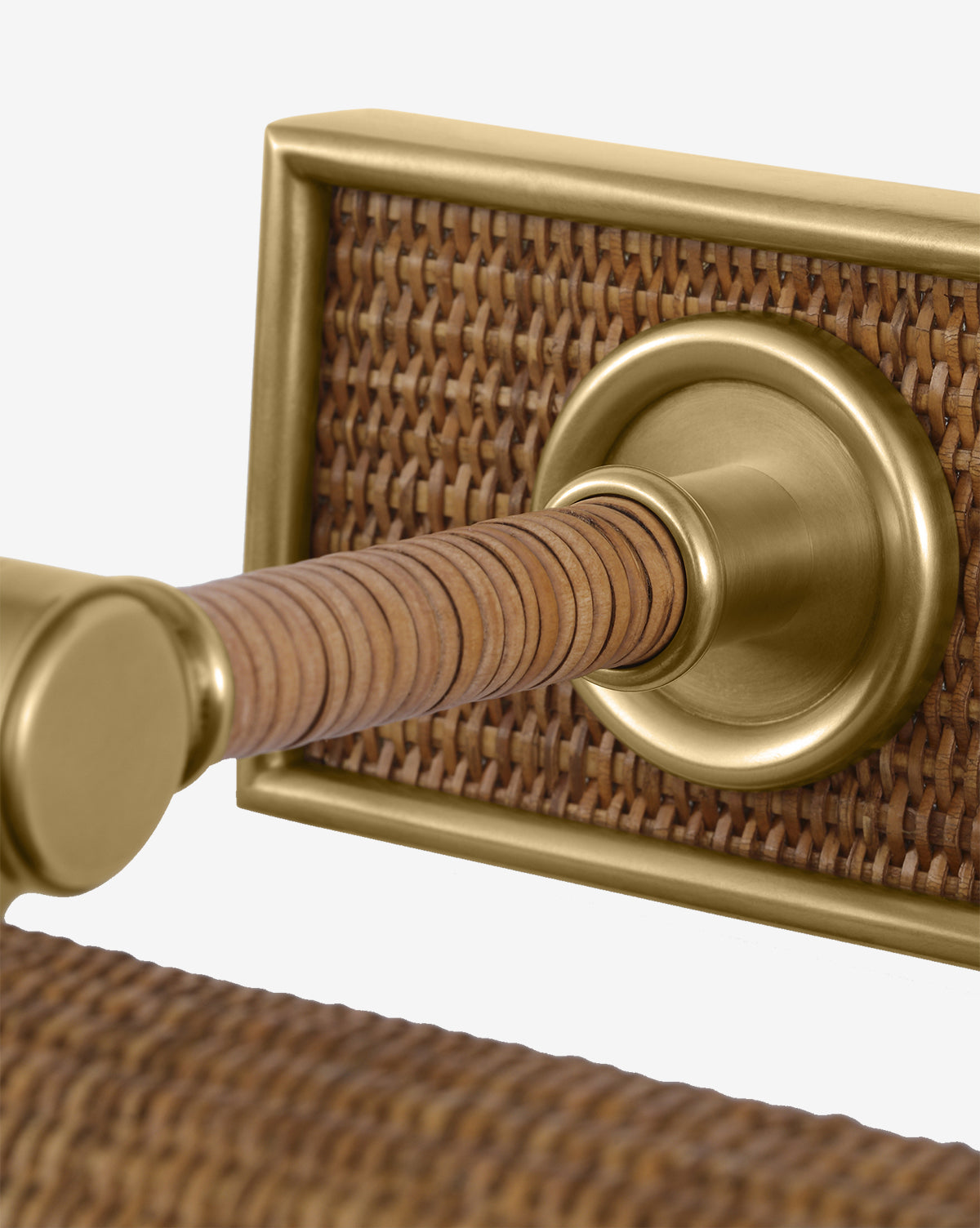 Close-up of the Halwell Picture Light illuminating a brass door handle with a woven rattan backplate and grip, highlighting the elegant mix of metallic and natural materials, by Vendixs