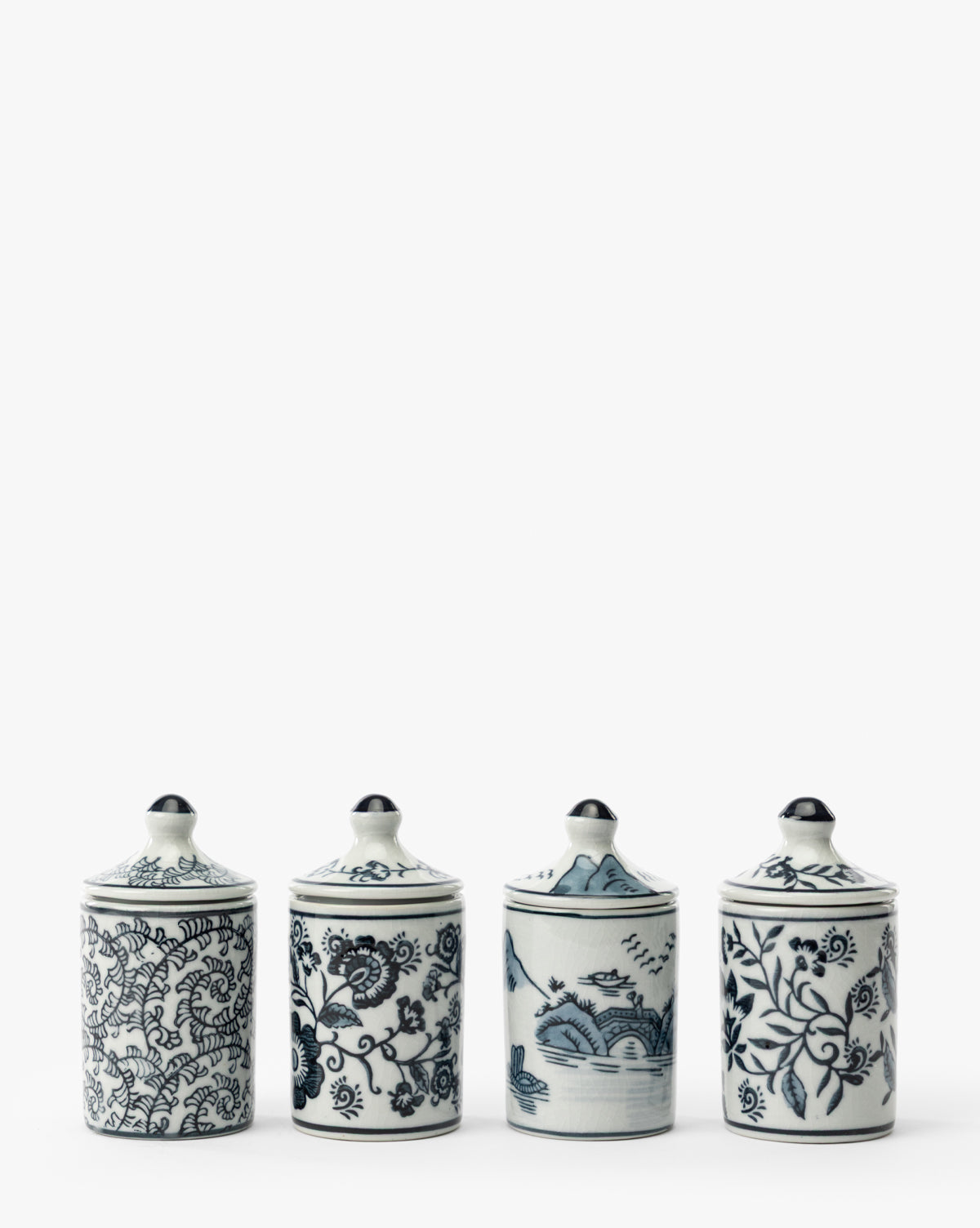The Hand-Painted Spice Jars (Set of 4) features white ceramic jars with blue lids, adorned with detailed floral and landscape designs. These artisanal kitchen accents are displayed in a row against a plain white background, by Vendixs